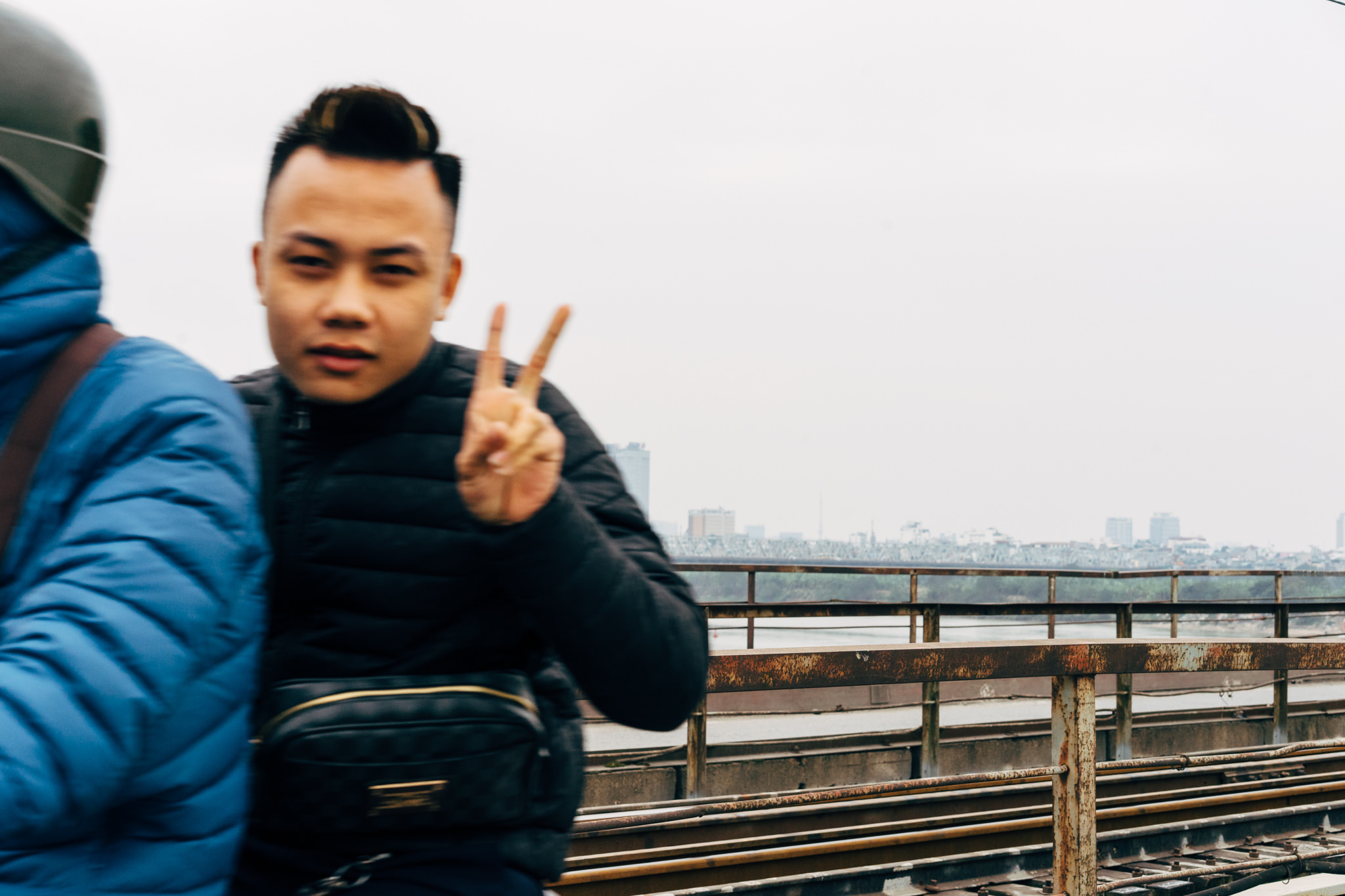 Man on scooter giving peace sign in Vietnam.