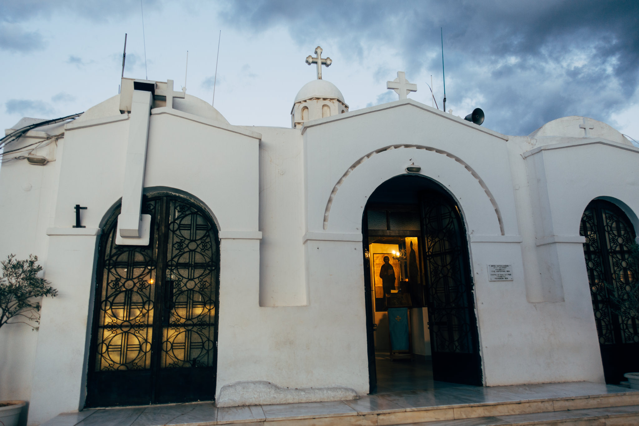 White church with open doors, showing an interior with religious iconography.