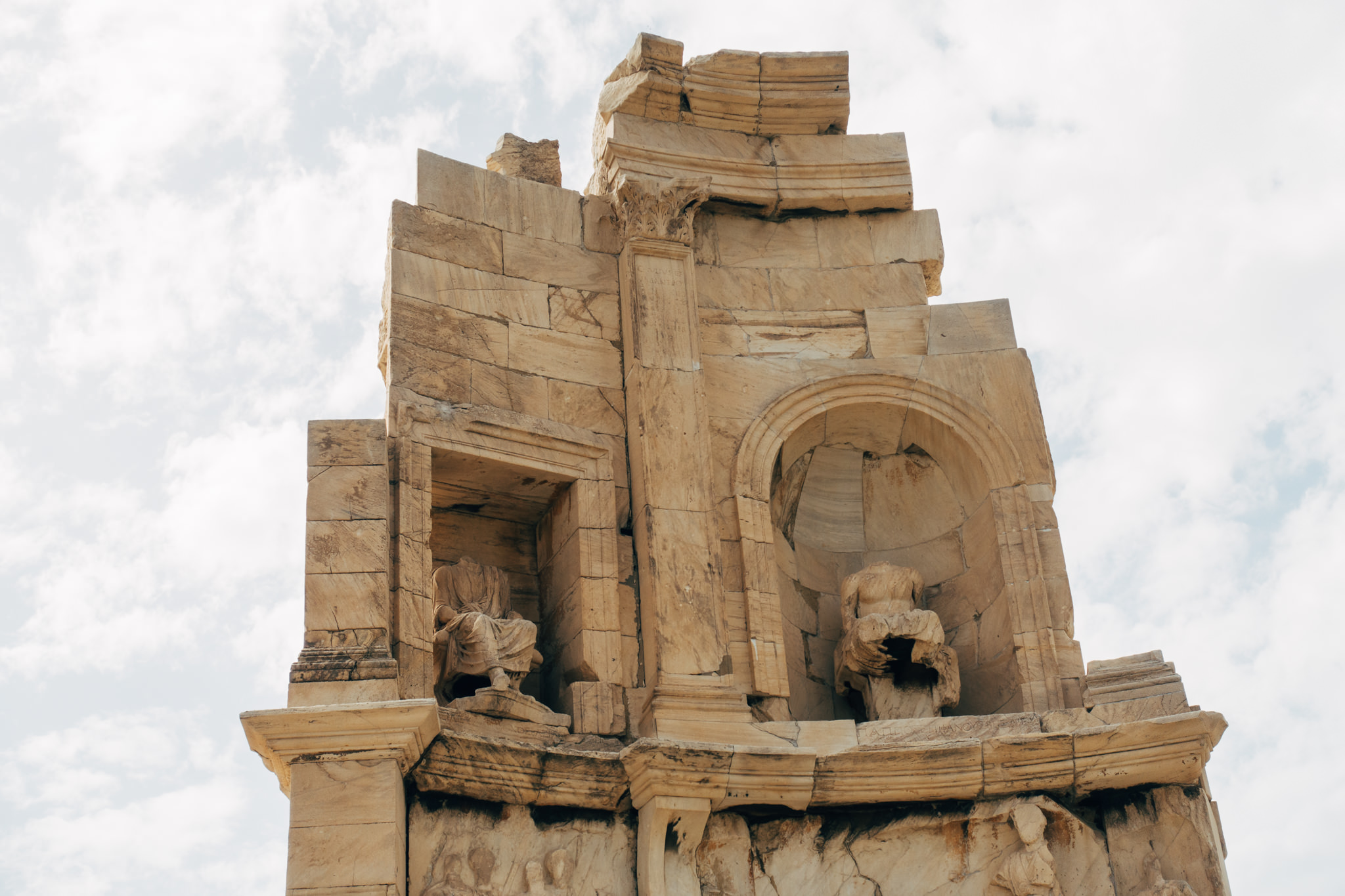 Philopappos Monument in Athens, showing stone carvings of seated figures in niches.