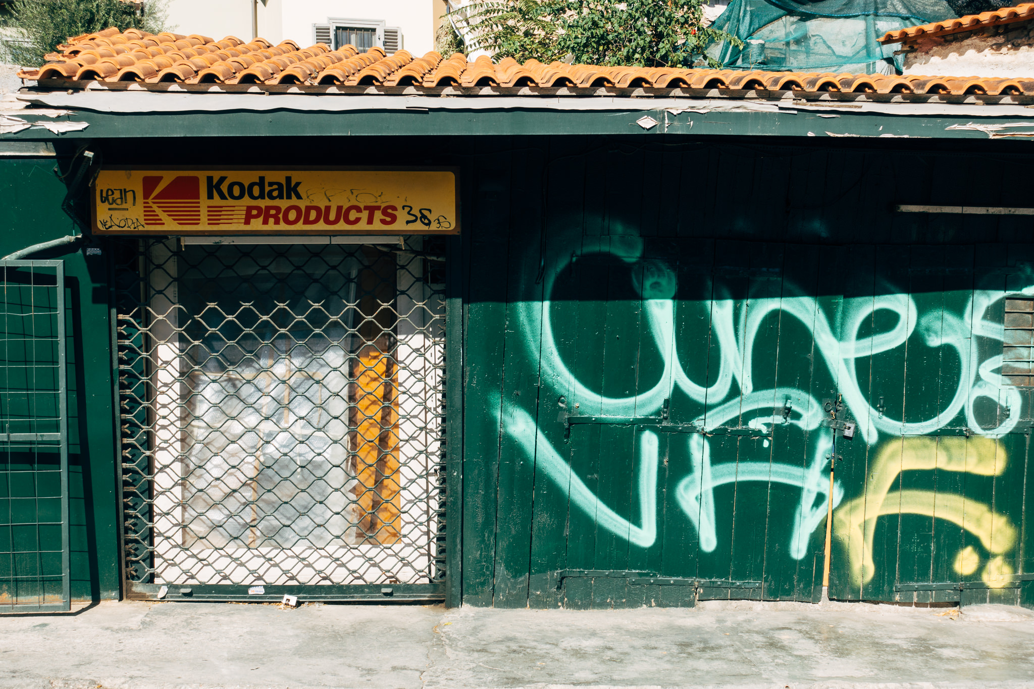 Graffiti-covered green doors of an abandoned Kodak Products store.