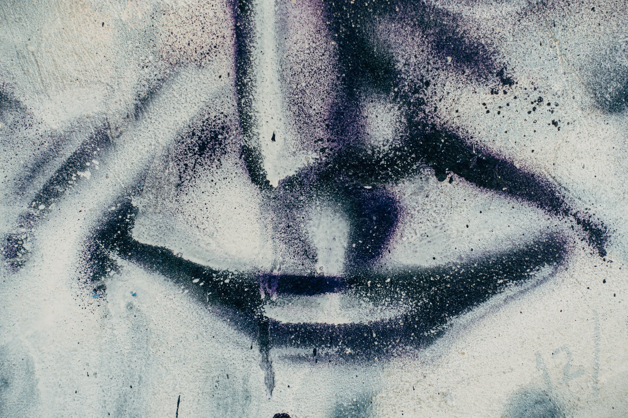 Graffiti of a mouth on a textured wall.