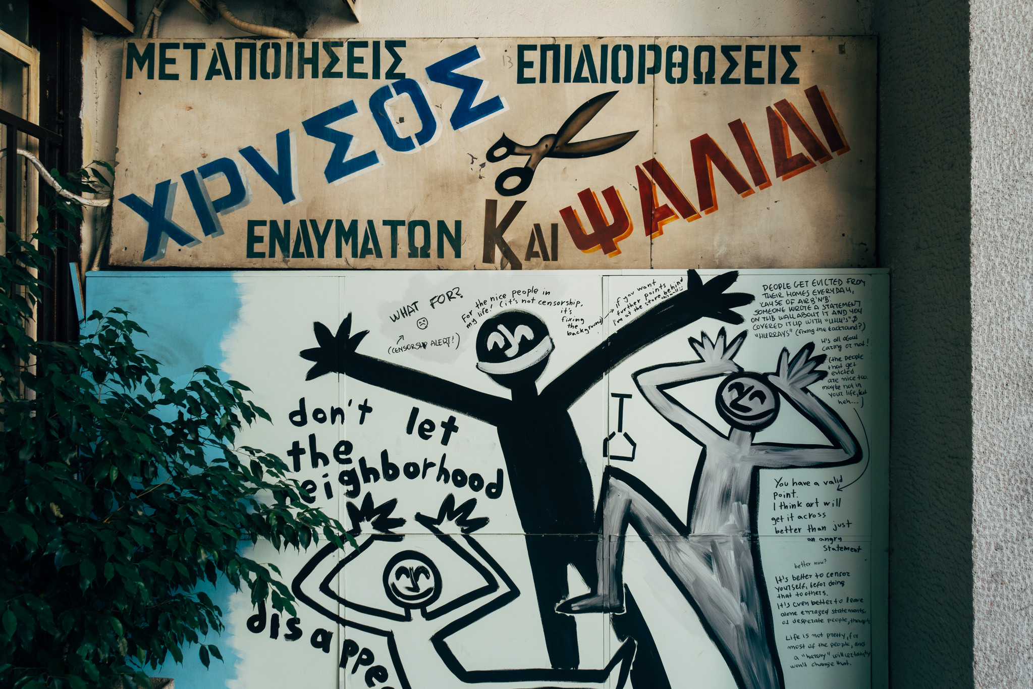 Graffiti depicting figures and text protesting neighborhood gentrification, overlaid on a faded sign.