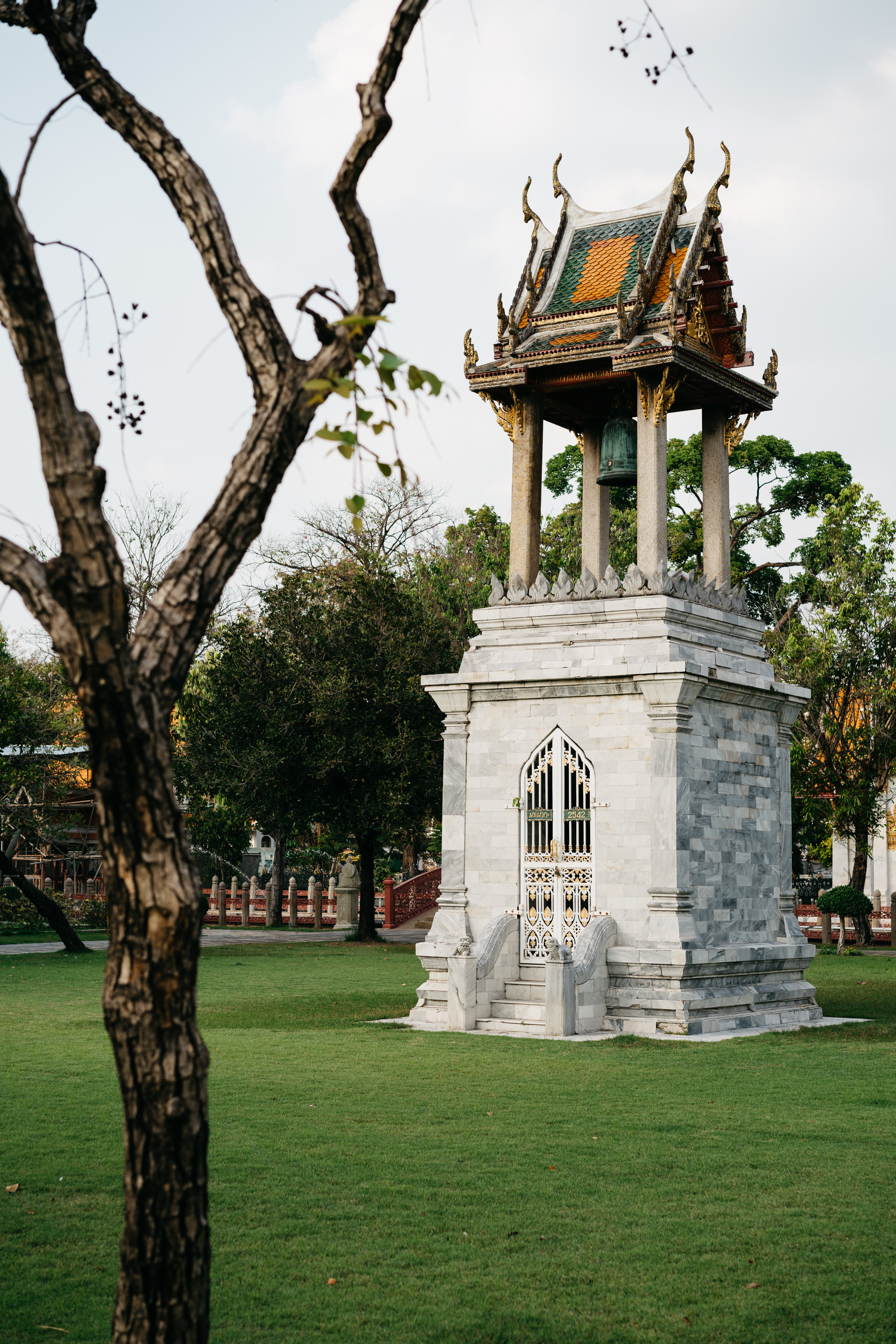 Marble bell tower with ornate roof at Wat Benchamabophit in Bangkok.