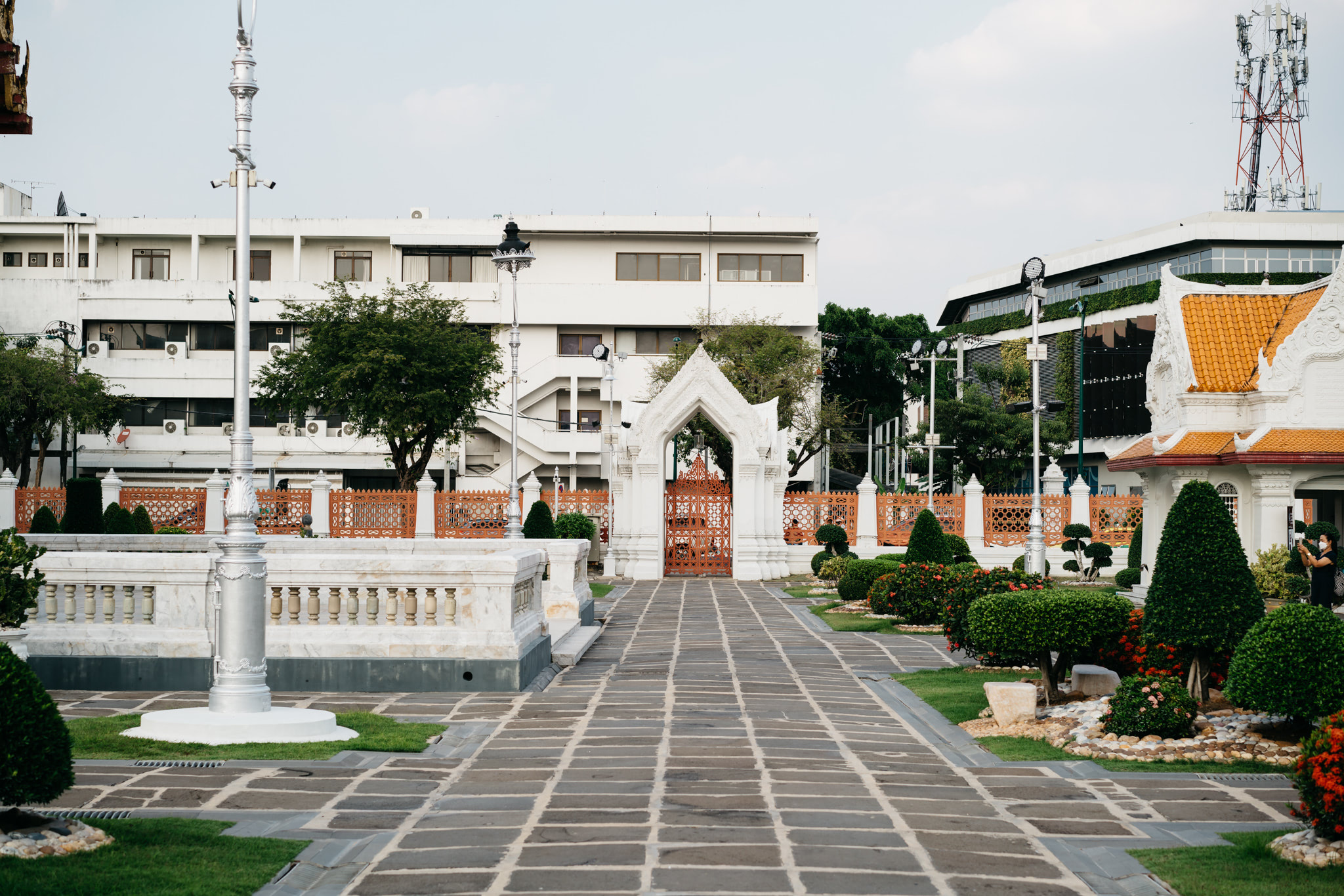 Wat Benchamabophit courtyard with ornate white gate and landscaping.