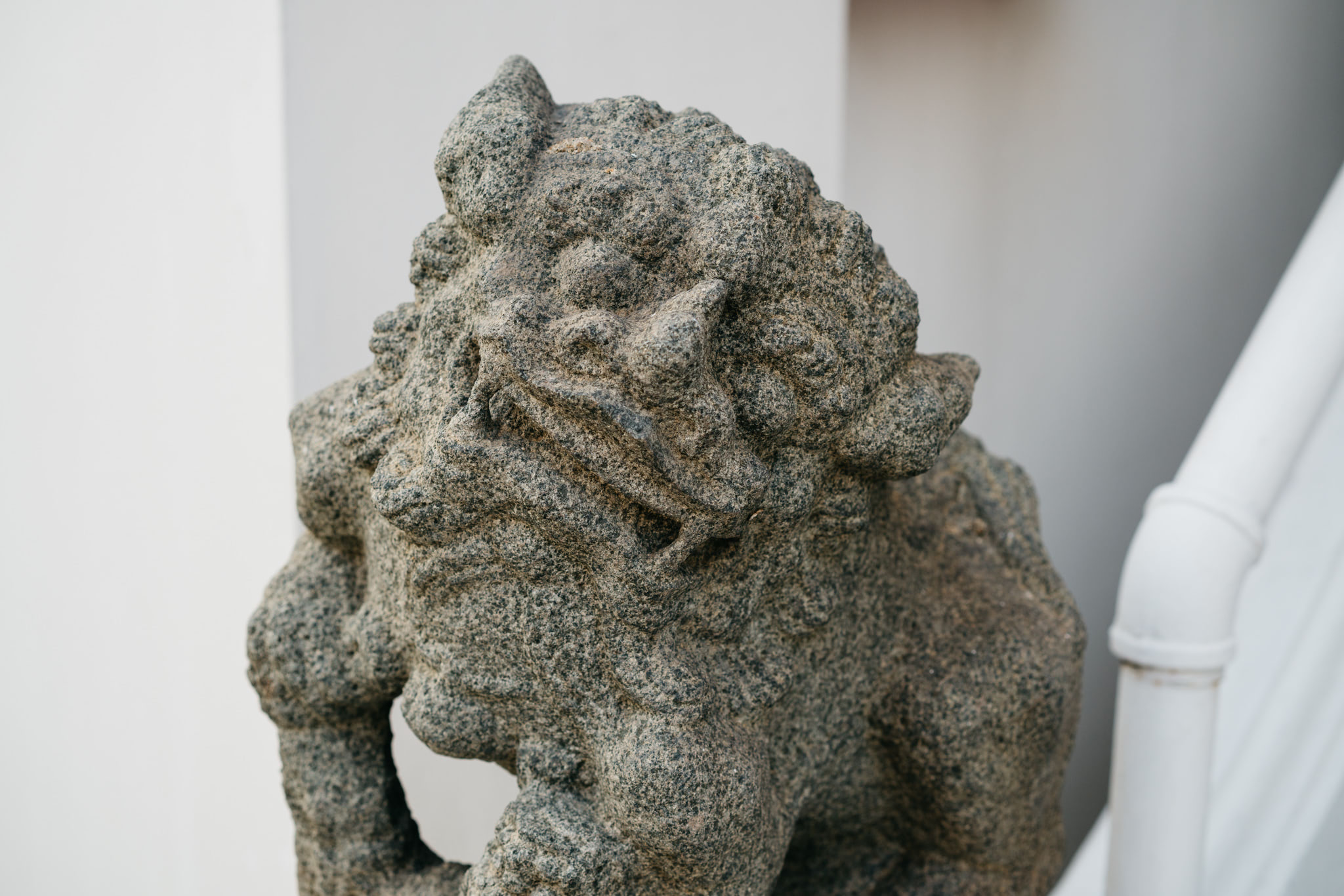 Close-up of a weathered stone lion statue.