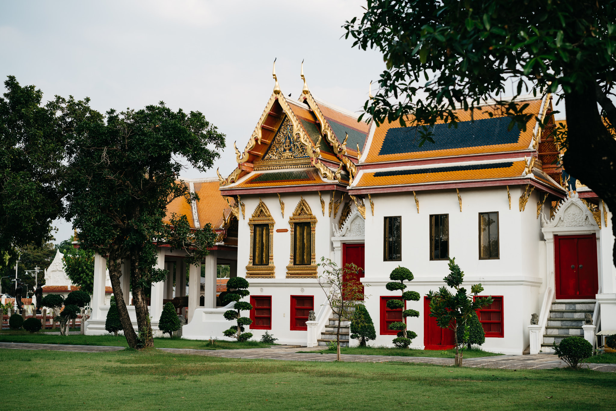 Wat Benchamabophit building in Bangkok with ornate roof and red doors.