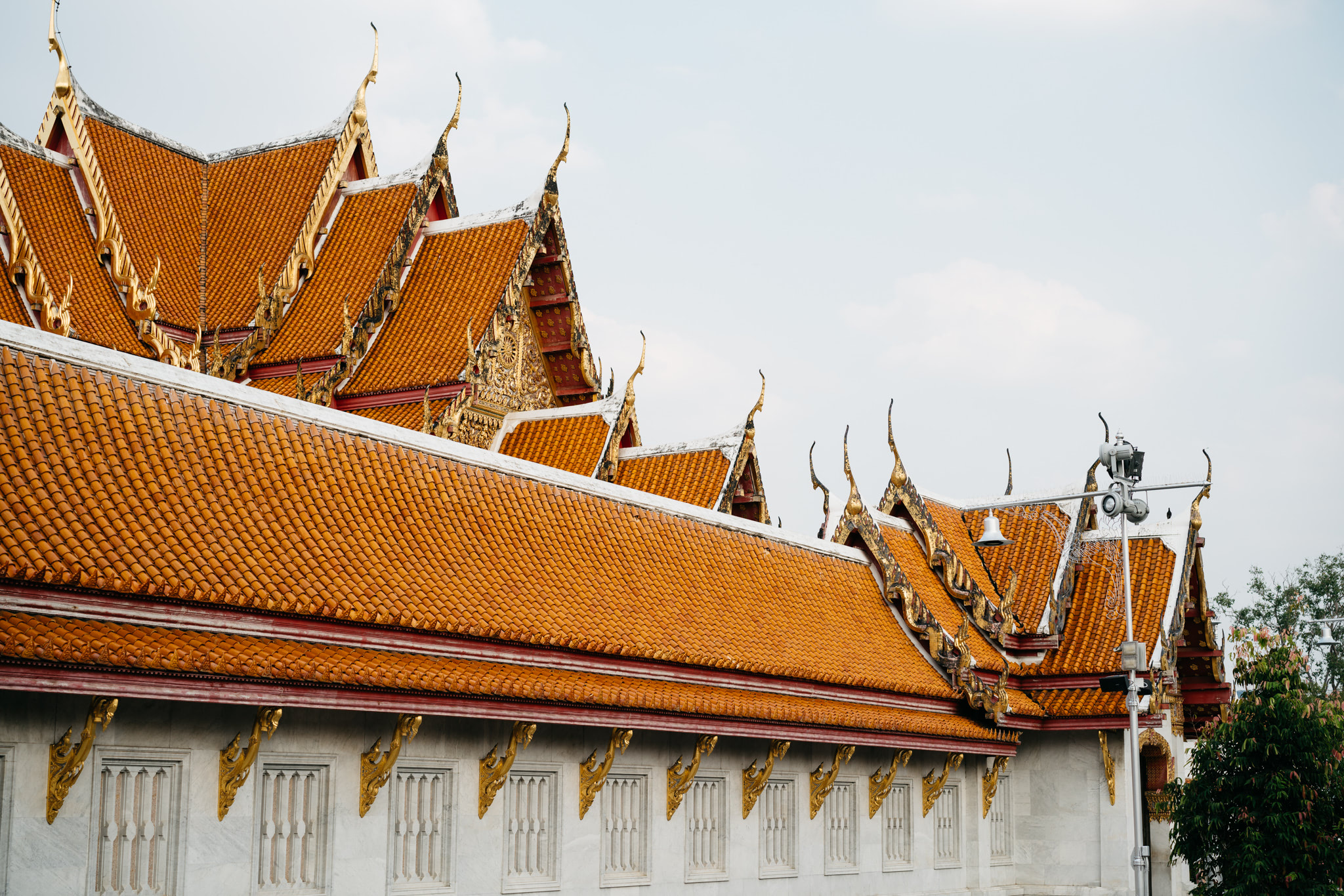 Wat Benchamabophit temple in Bangkok, orange roof and white walls.
