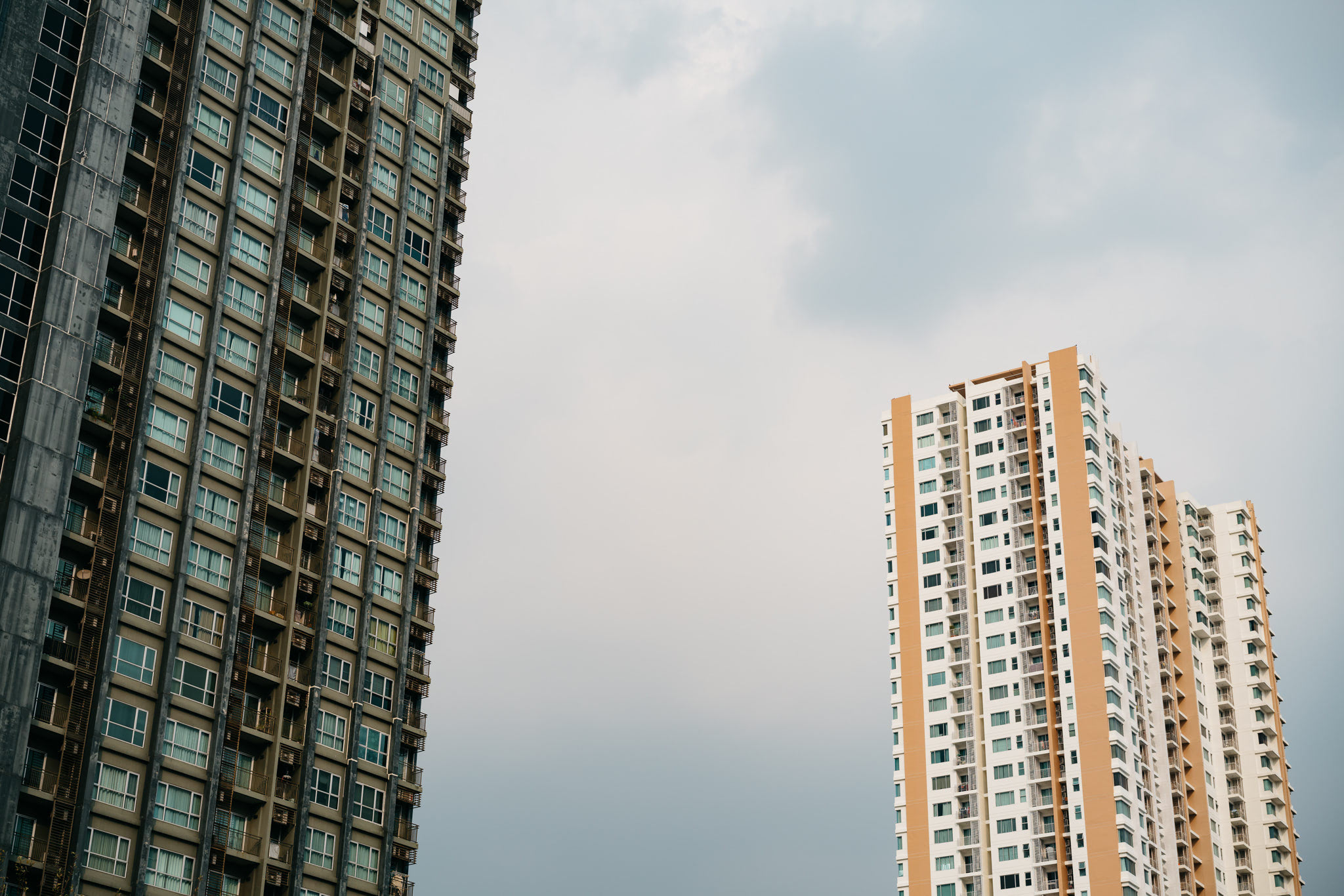 Two residential high-rise buildings against a cloudy sky.