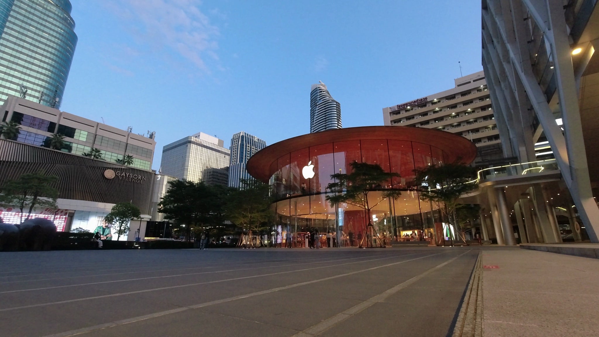Apple store at dusk, surrounded by skyscrapers.