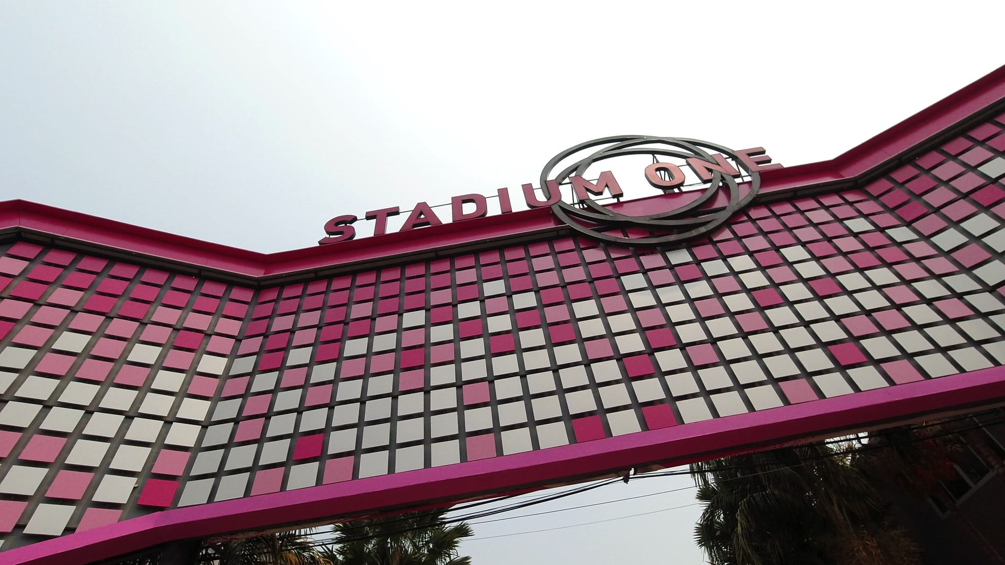 Stadium One Bangkok sign with pink and white square patterned facade.