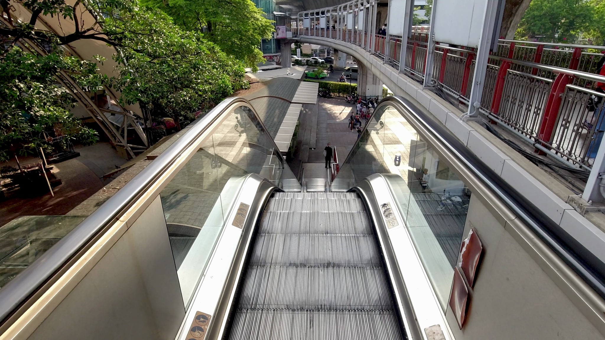 Overhead view of an empty escalator leading down to a street scene.