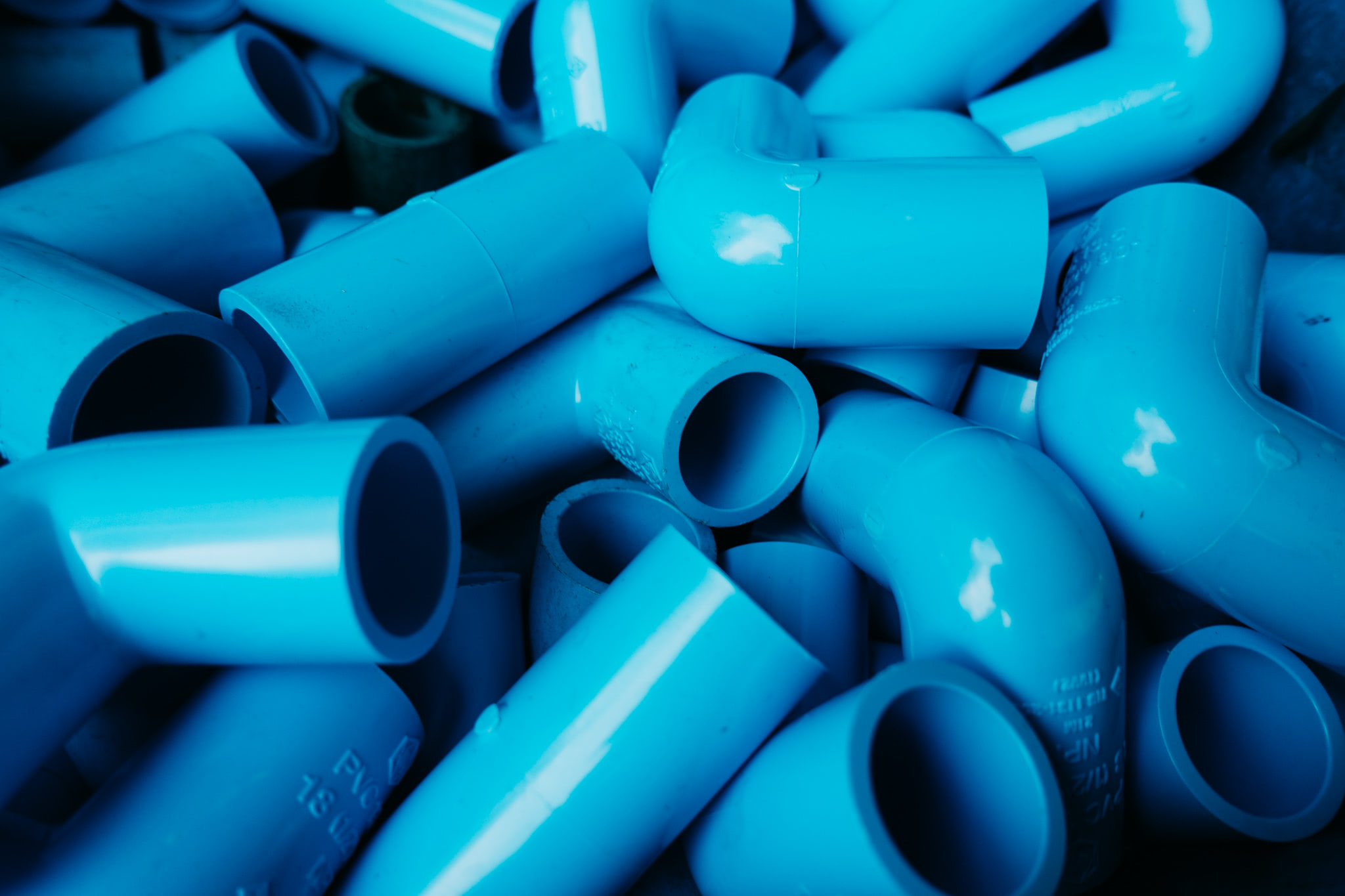 Pile of blue PVC pipes and fittings.