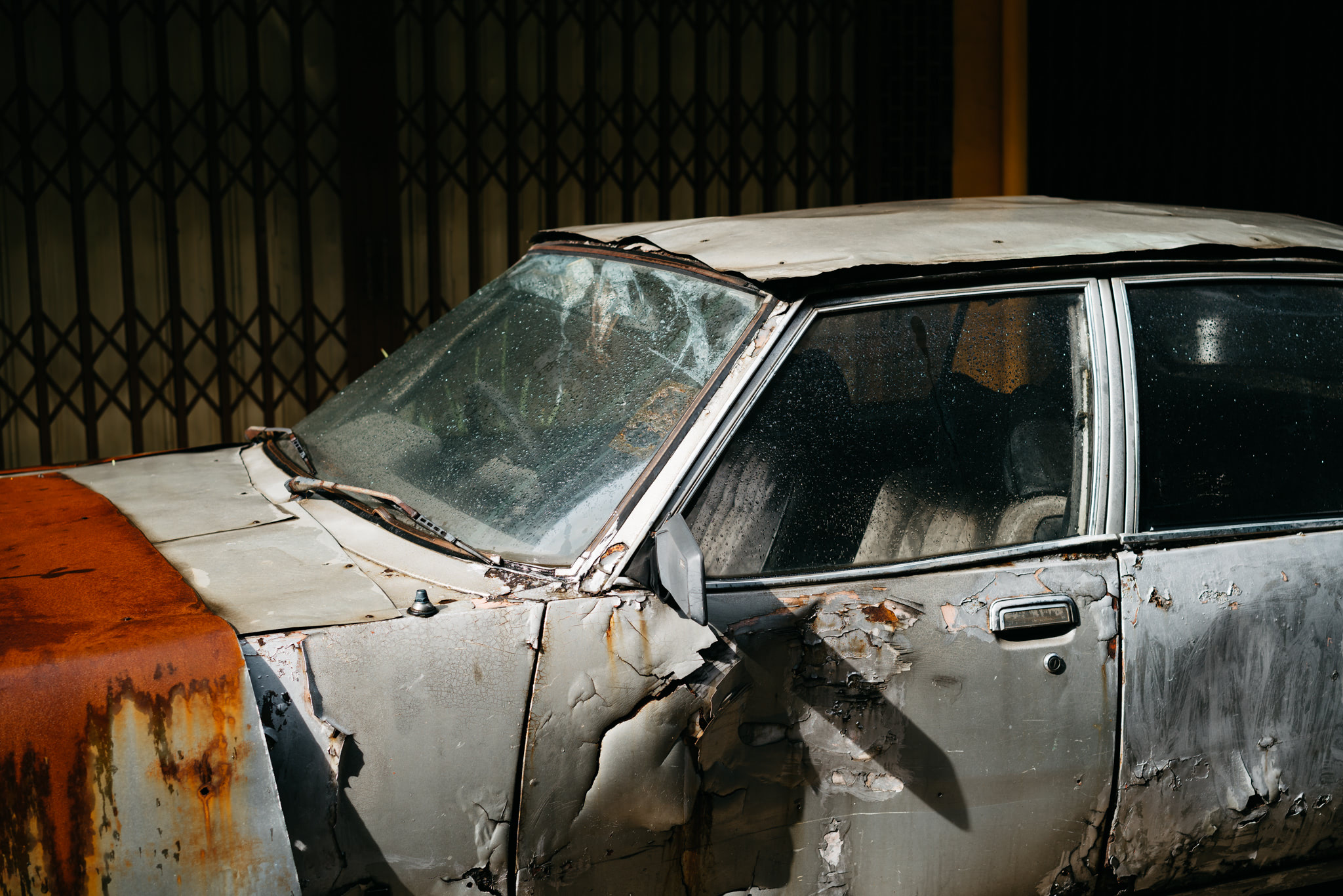 Rusty, damaged car awaiting demolition.