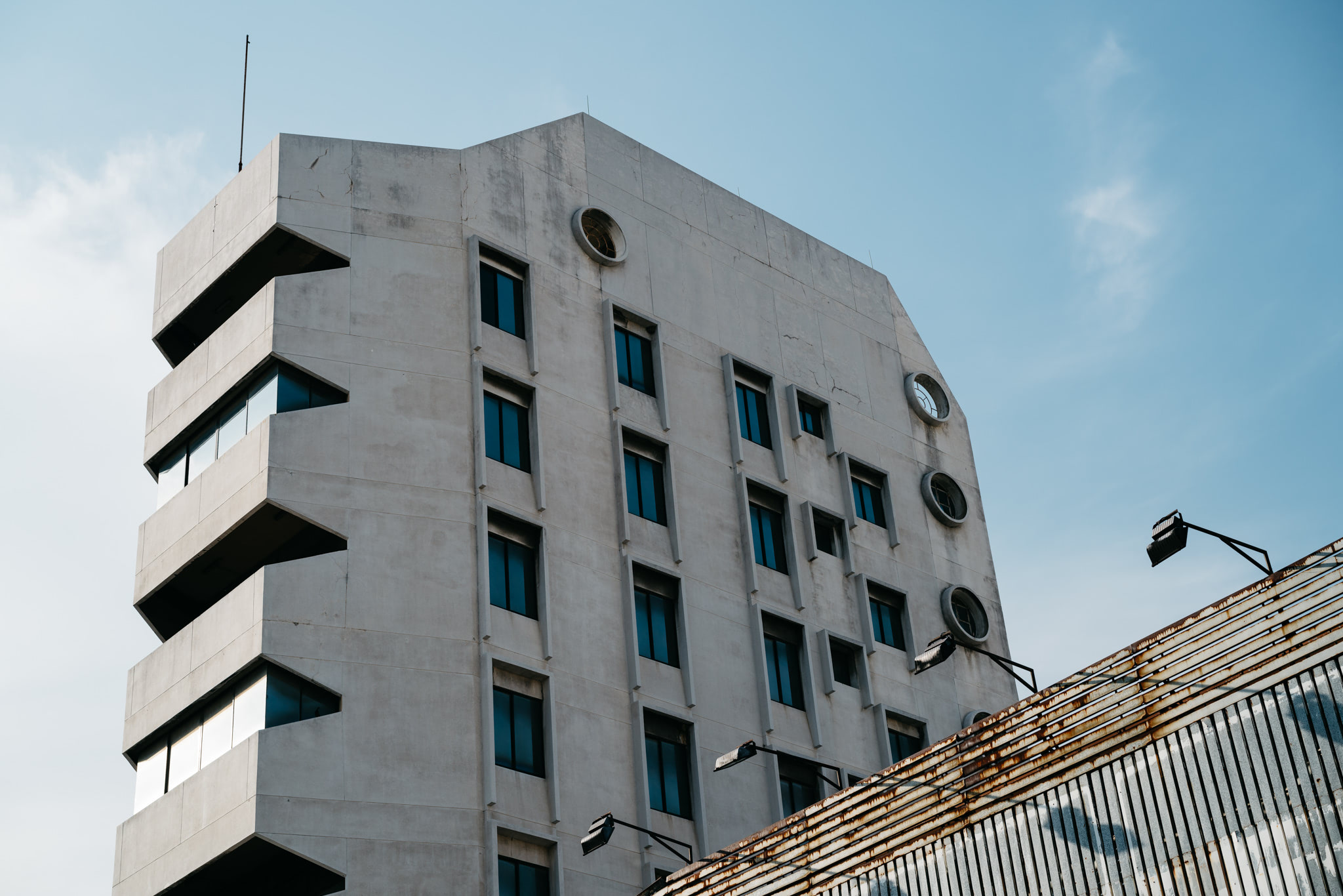 Low-angle view of a concrete building with rectangular windows.