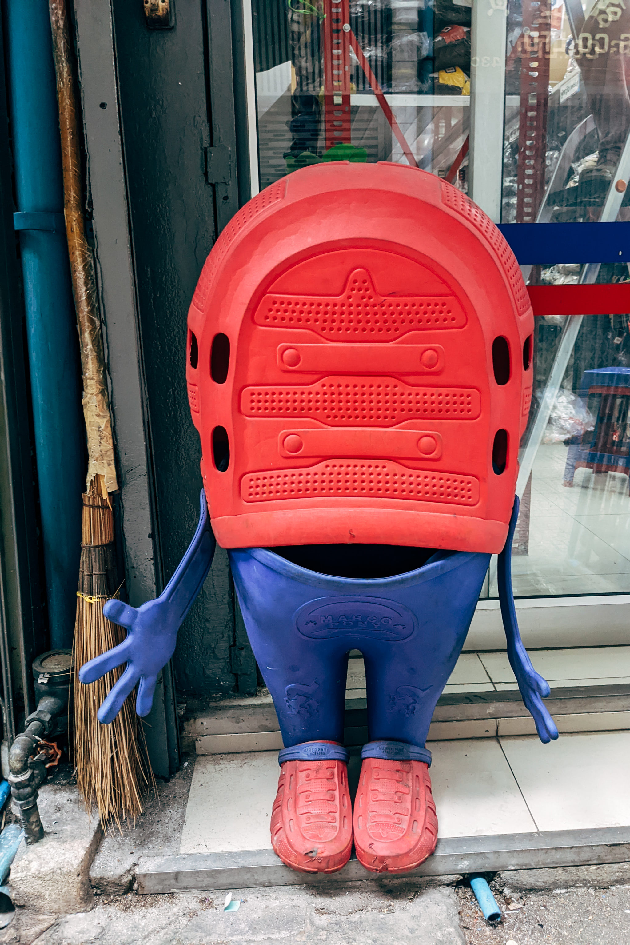A figure made from red and blue plastic clogs, resembling a person.