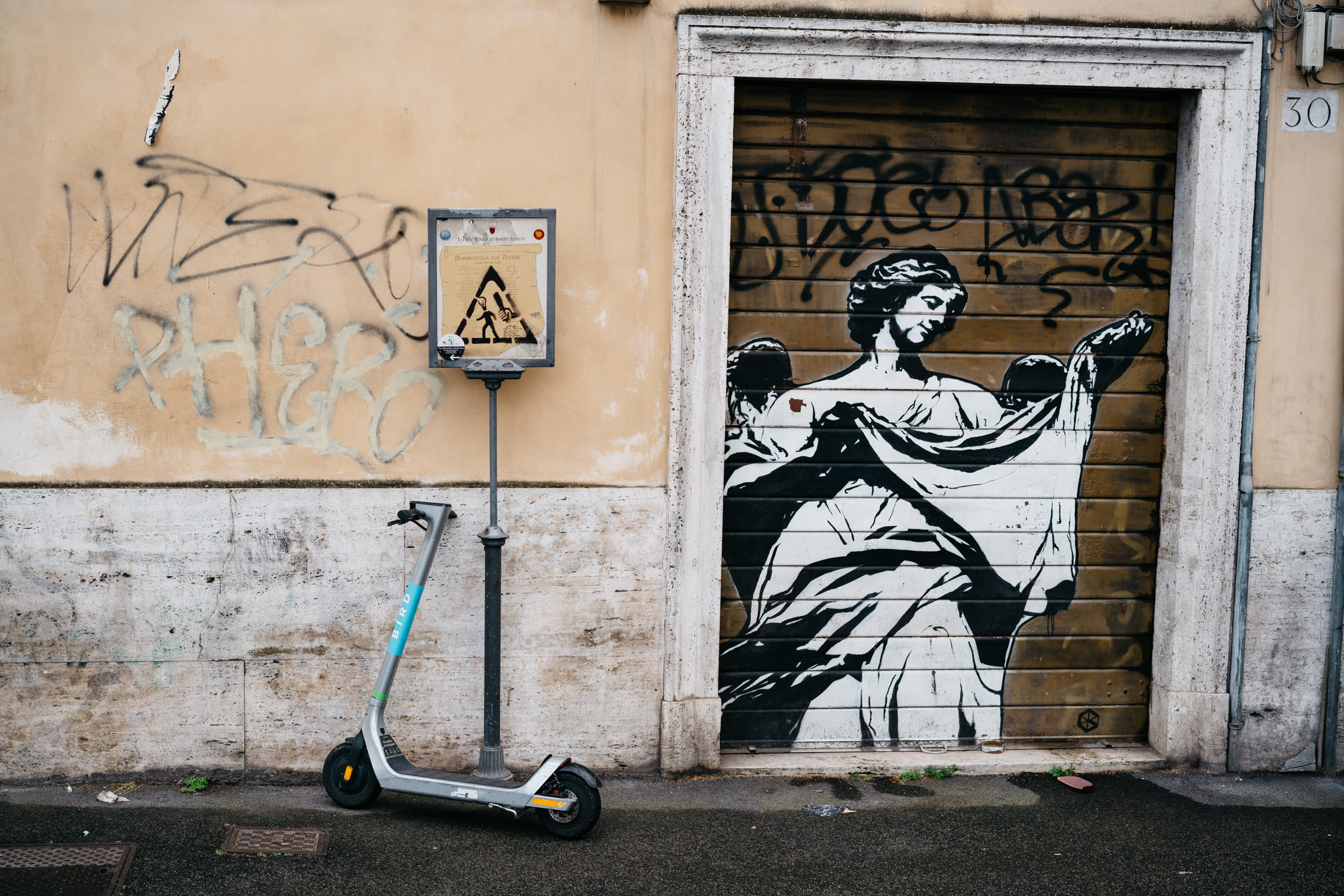 Electric scooter parked next to a graffiti-covered garage door depicting a classical statue in Rome.