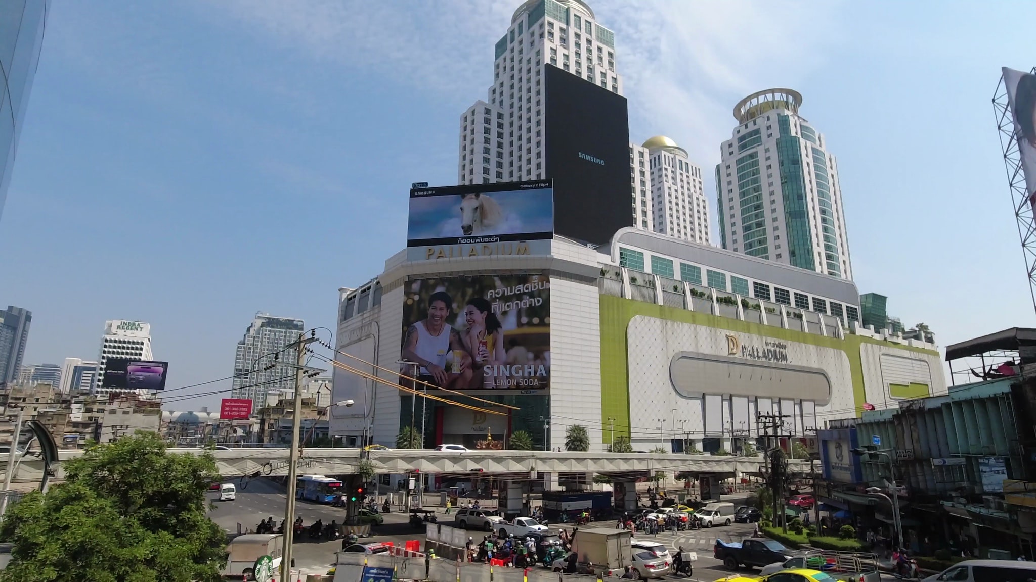 Bangkok street scene with Palladium shopping mall and tall buildings.