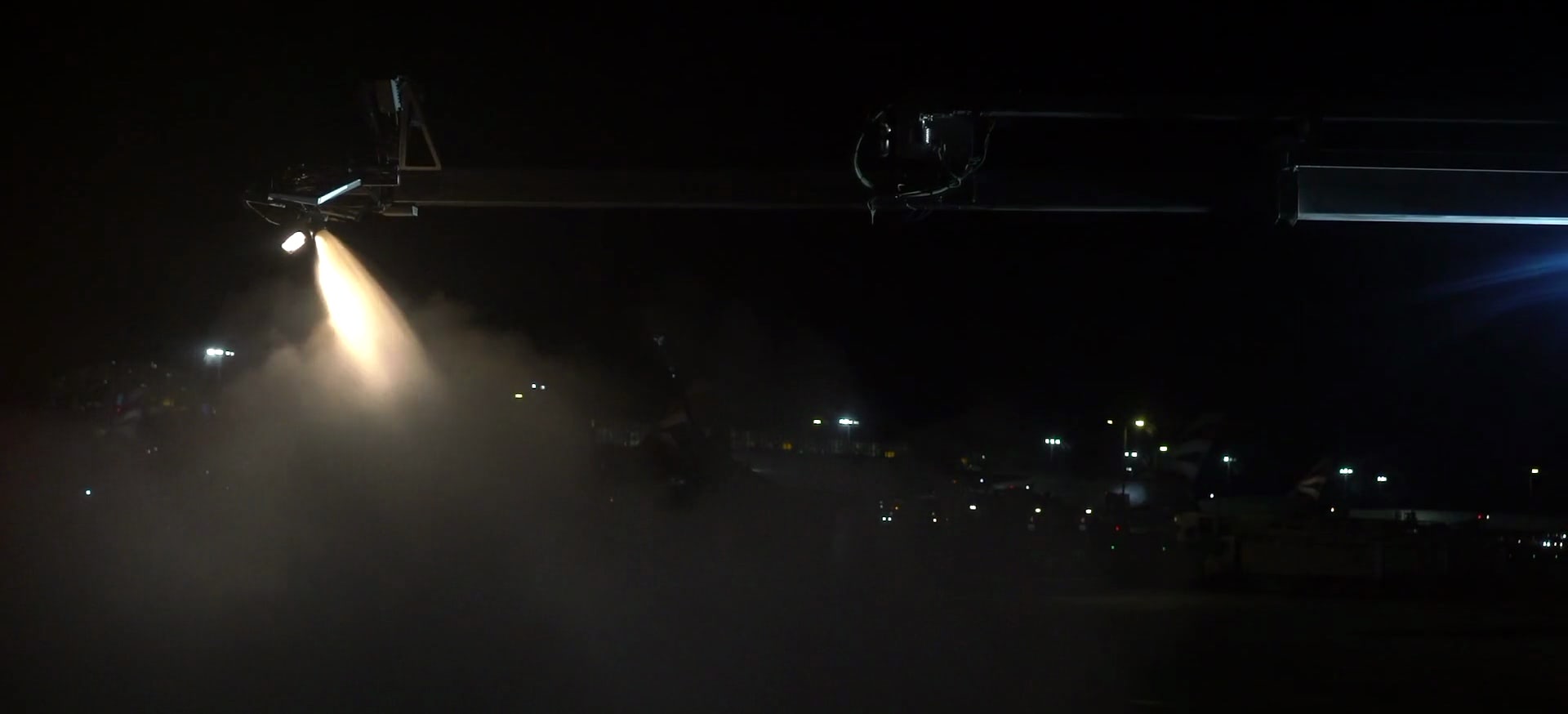 Nighttime de-icing of an airplane at London Heathrow Airport.
