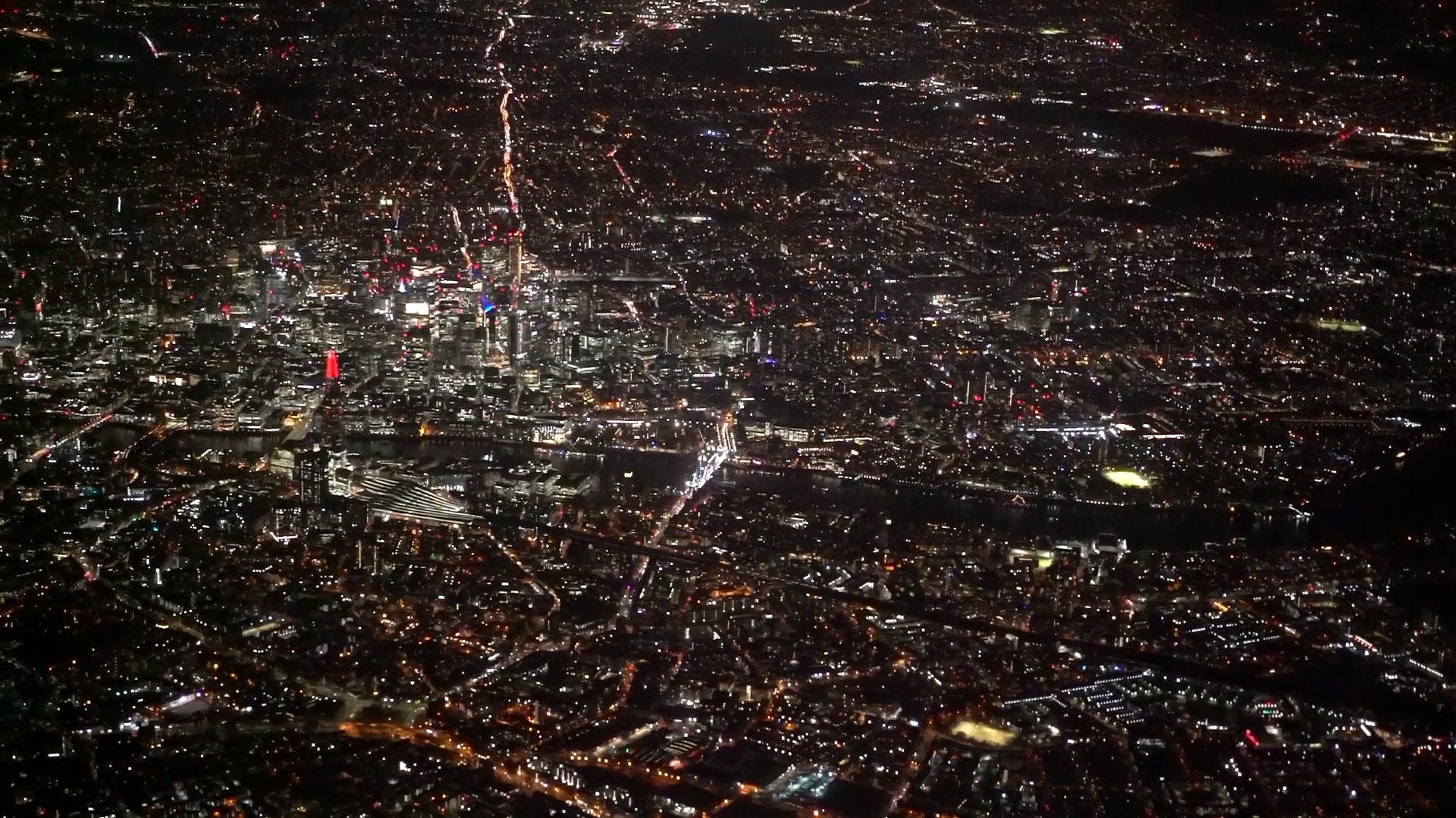 Aerial view of London at night, showing city lights.