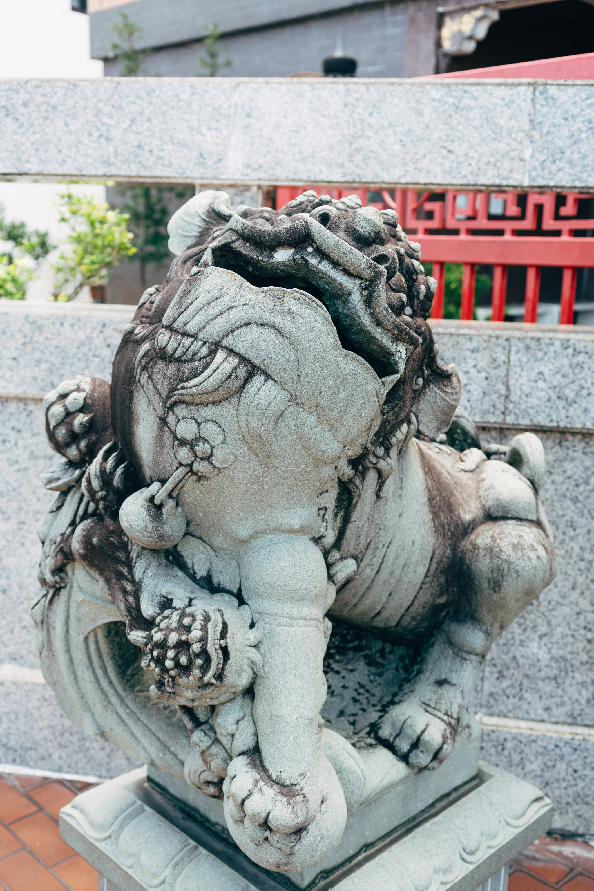 Weathered stone lion statue at a temple.