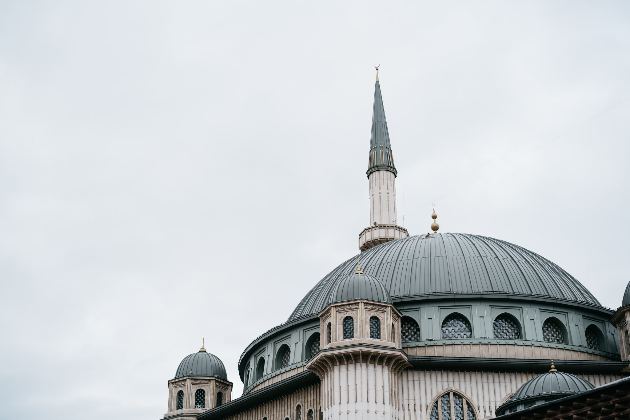 Taksim Mosque dome and minaret against a cloudy sky.
