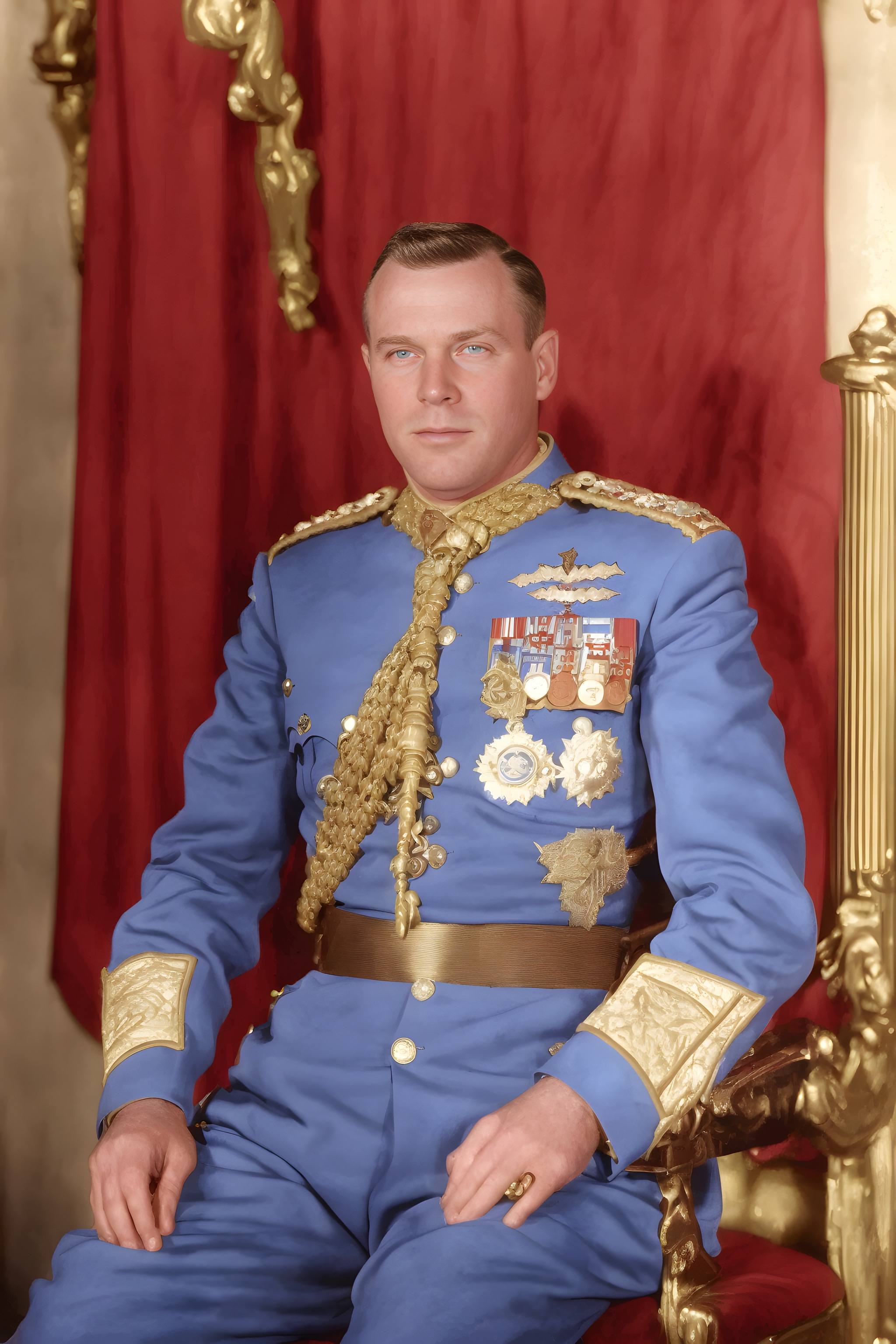 Portrait of a man in a blue military uniform with gold embellishments, seated on an ornate throne.