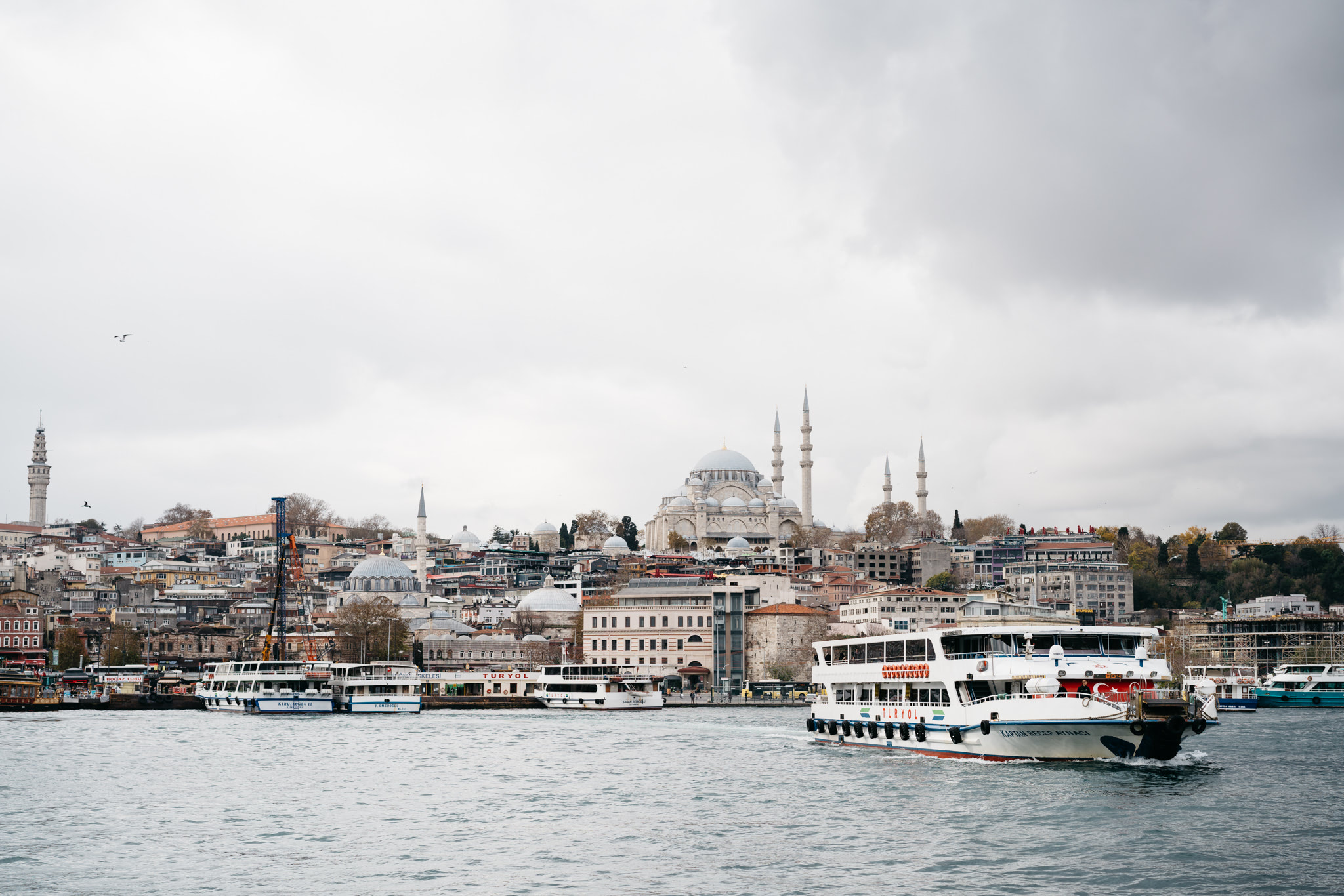 Istanbul cityscape with a mosque and ferry boats on the water.