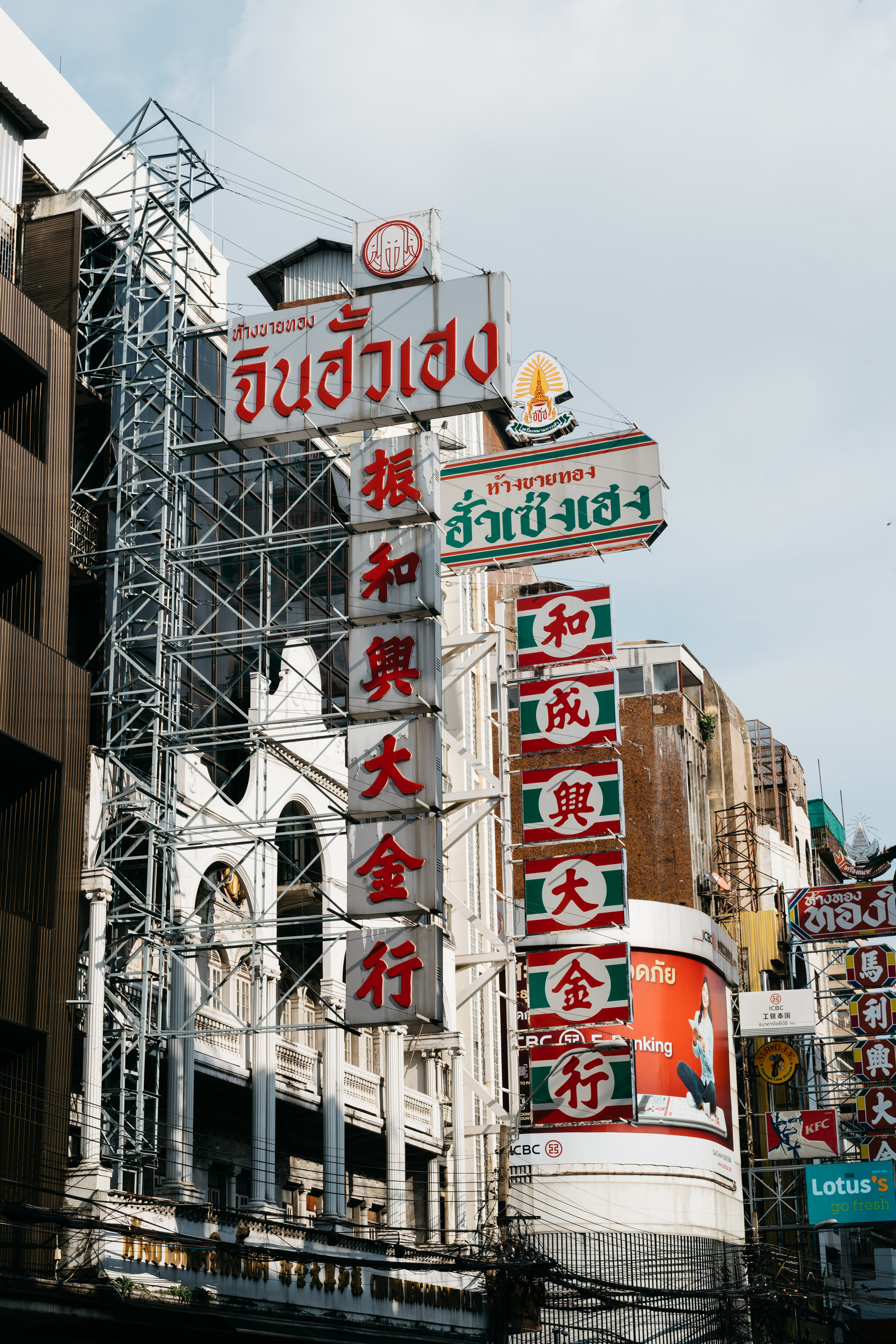 Thai shopping district with numerous signs in Thai and Chinese characters on buildings.