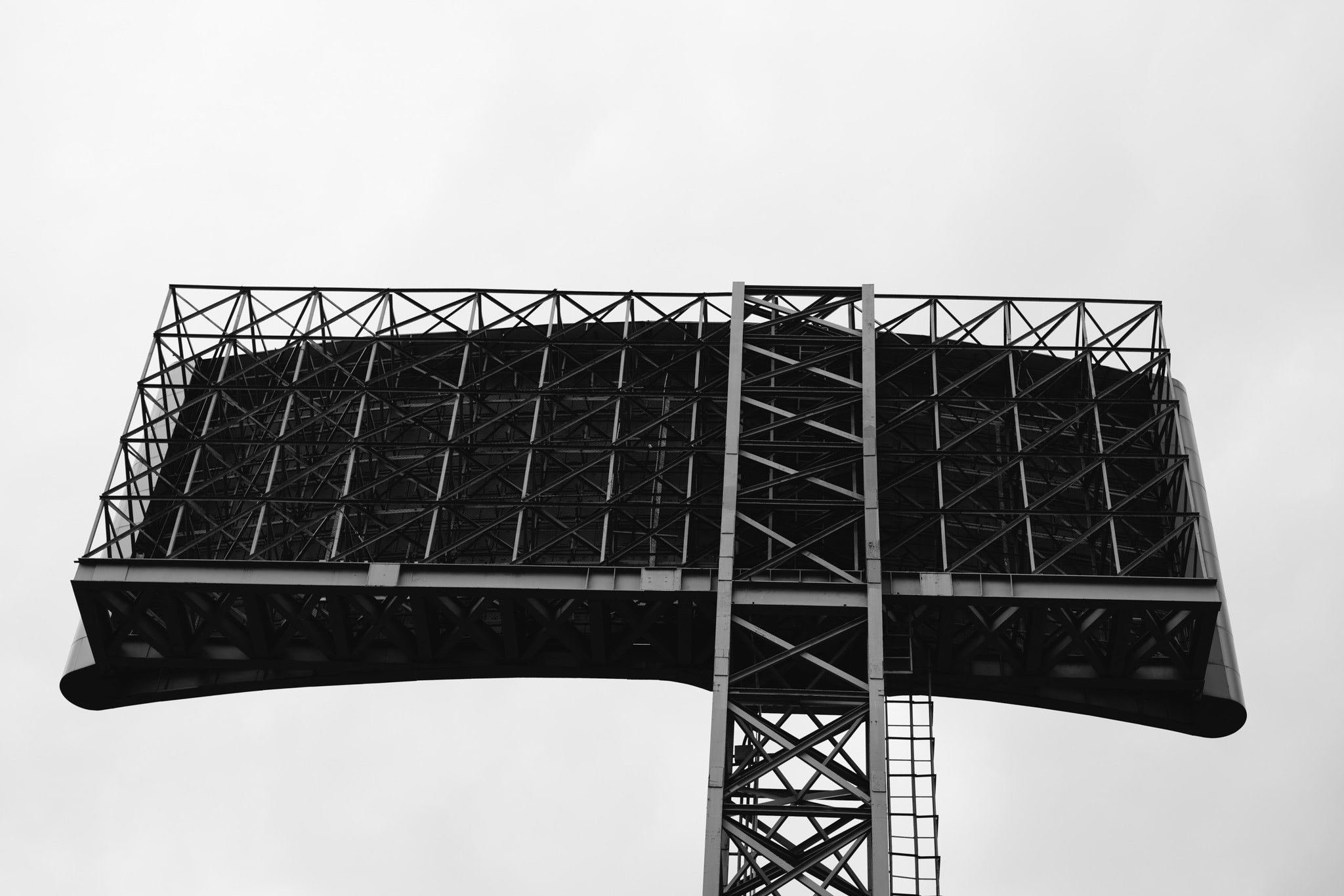 Large metal billboard structure against a light sky.