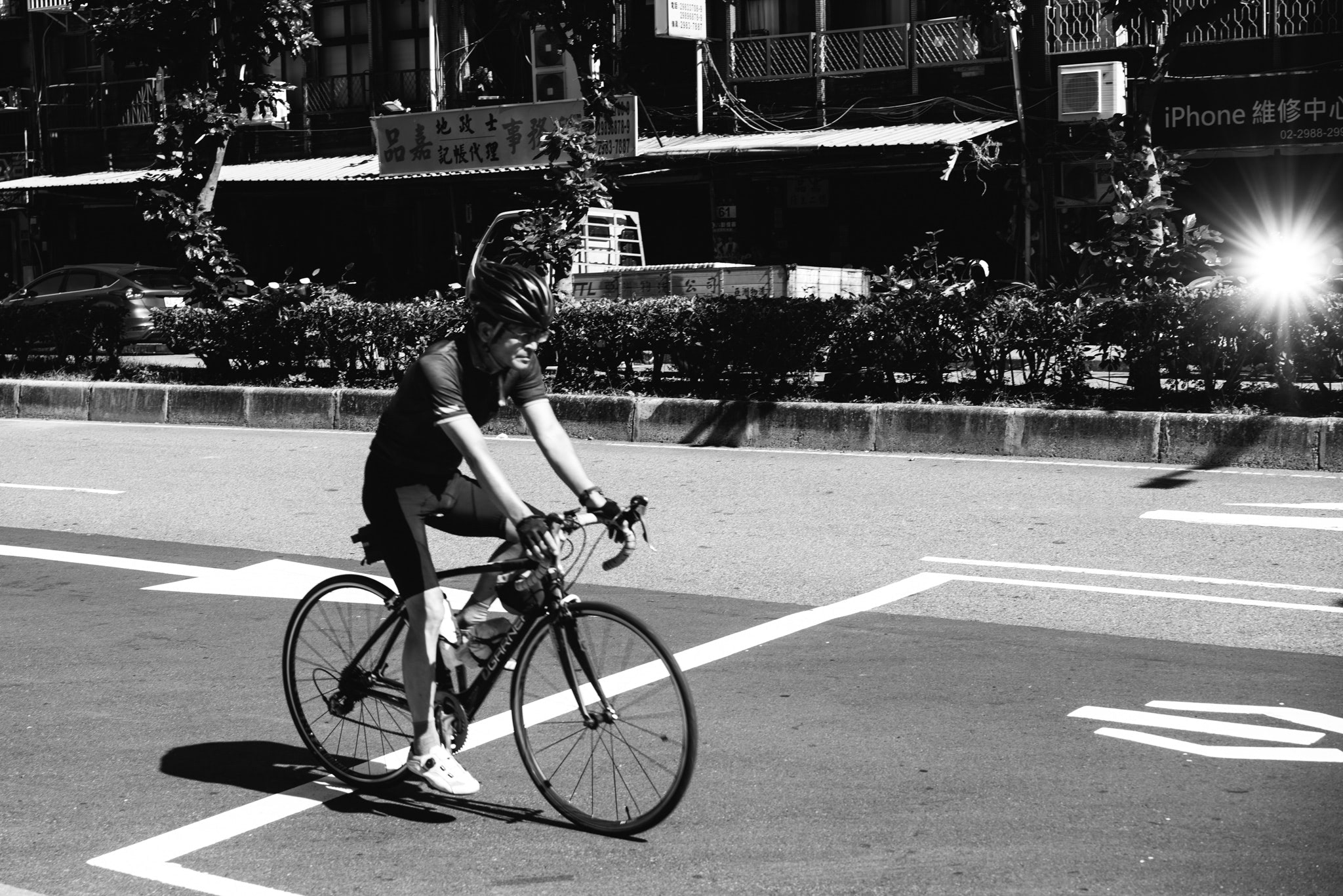 Man riding road bicycle on city street.