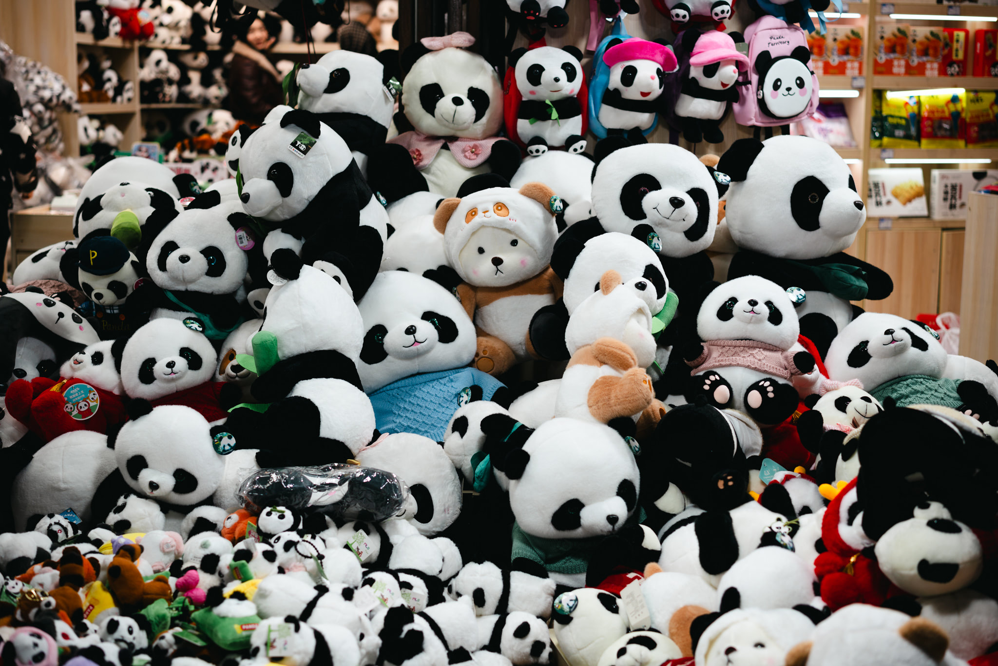 A large pile of panda plush toys in a store.