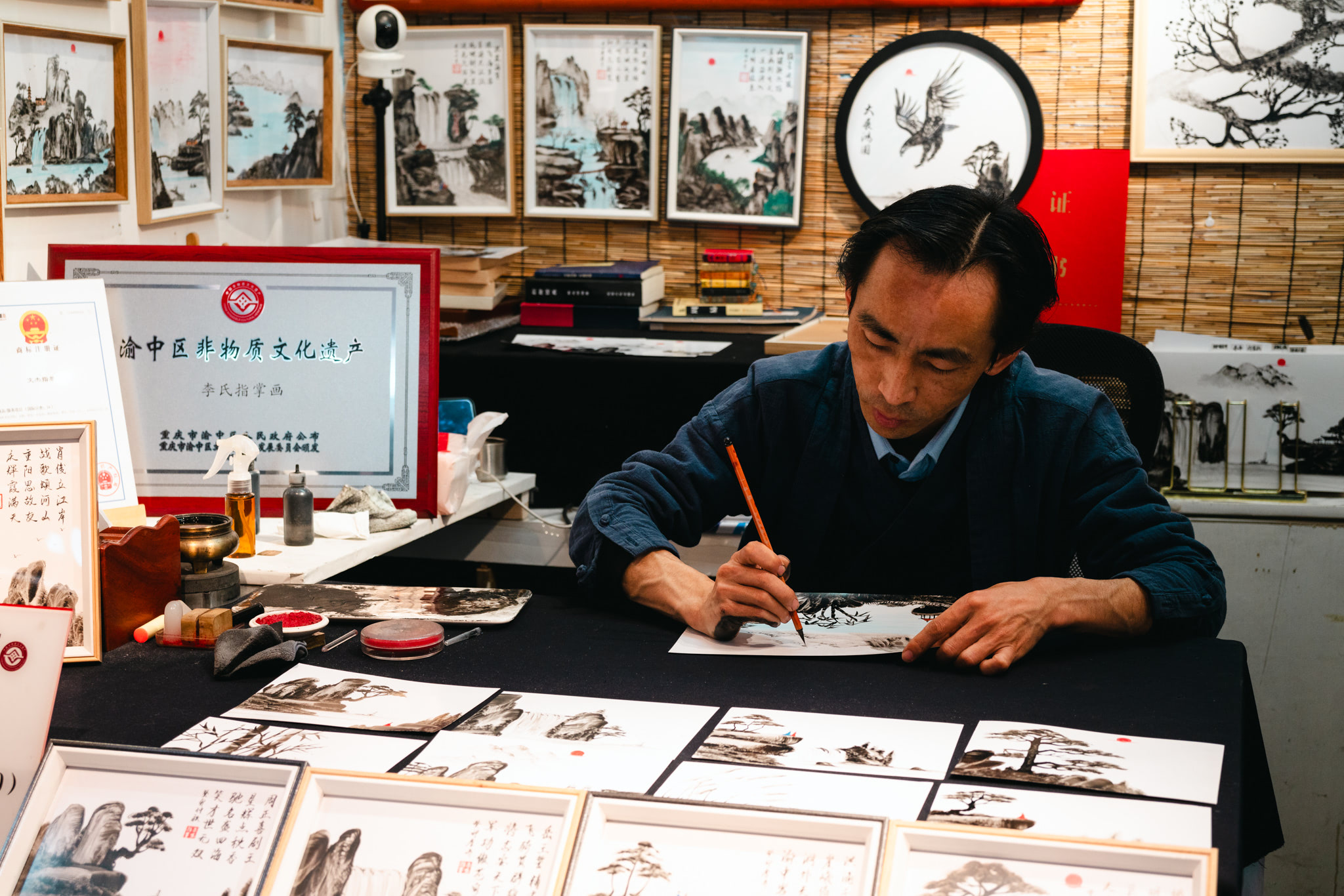 A man in Chongqing, China, paints a traditional Chinese landscape painting.