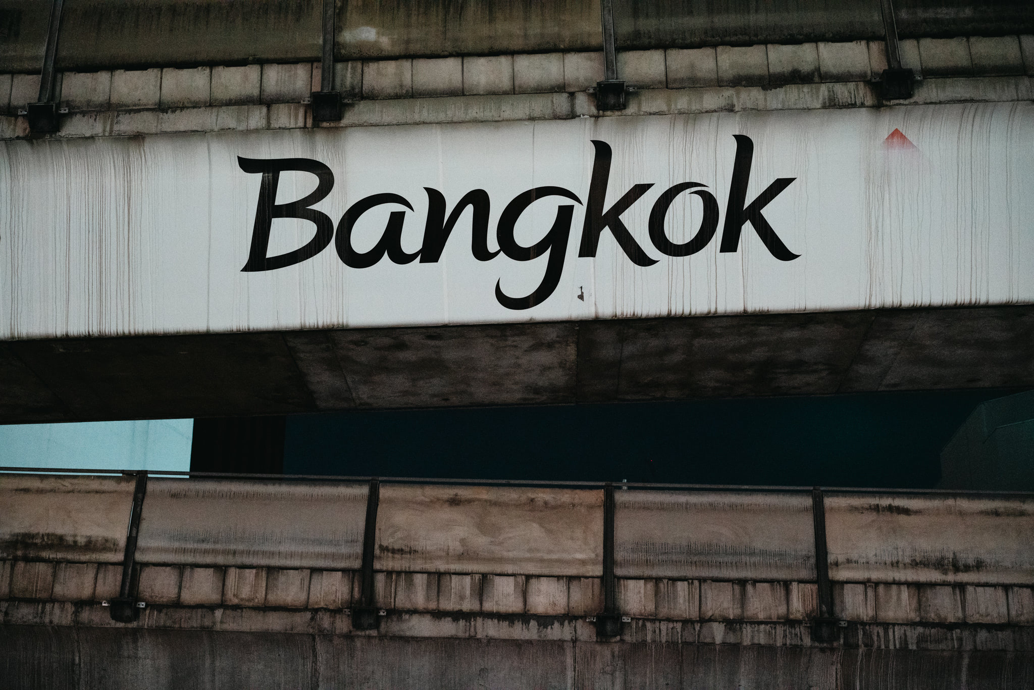 Bangkok sign on a weathered concrete structure.