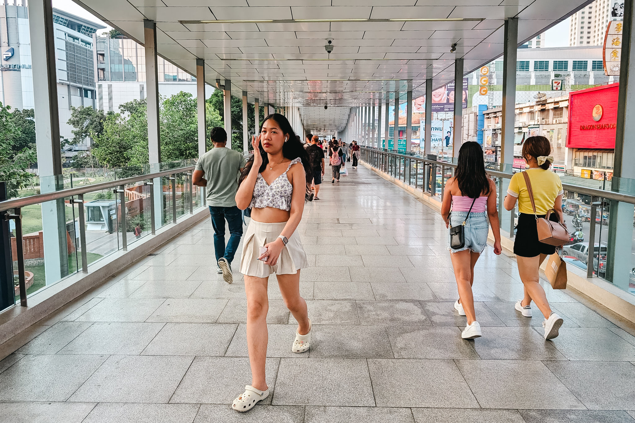 Young woman walking on a Bangkok pedestrian overpass.
