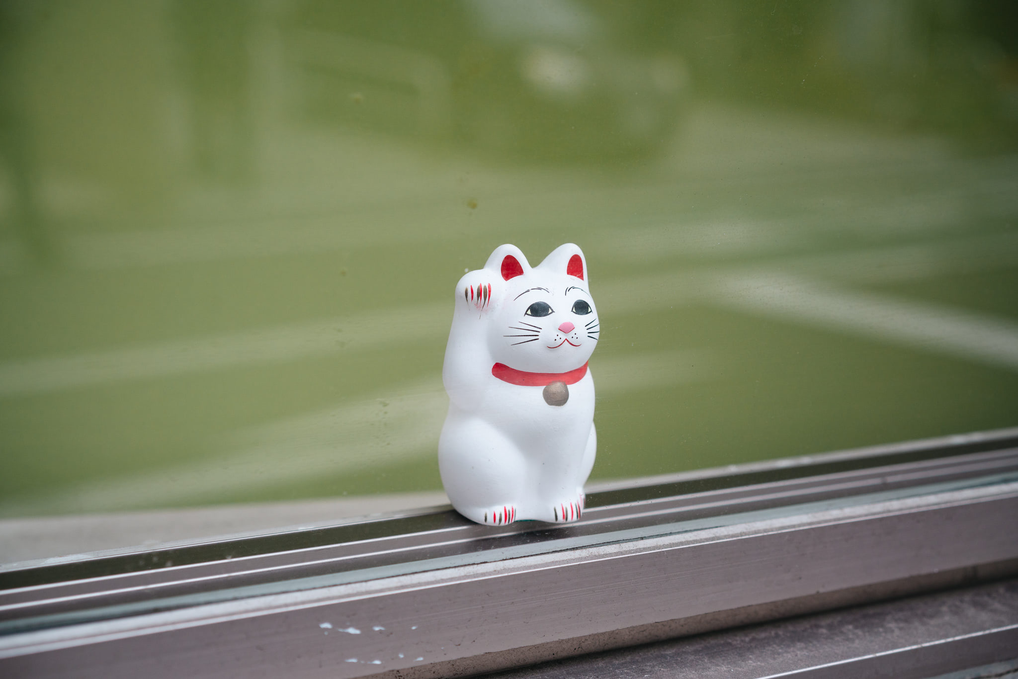 White Maneki-neko figurine on windowsill.