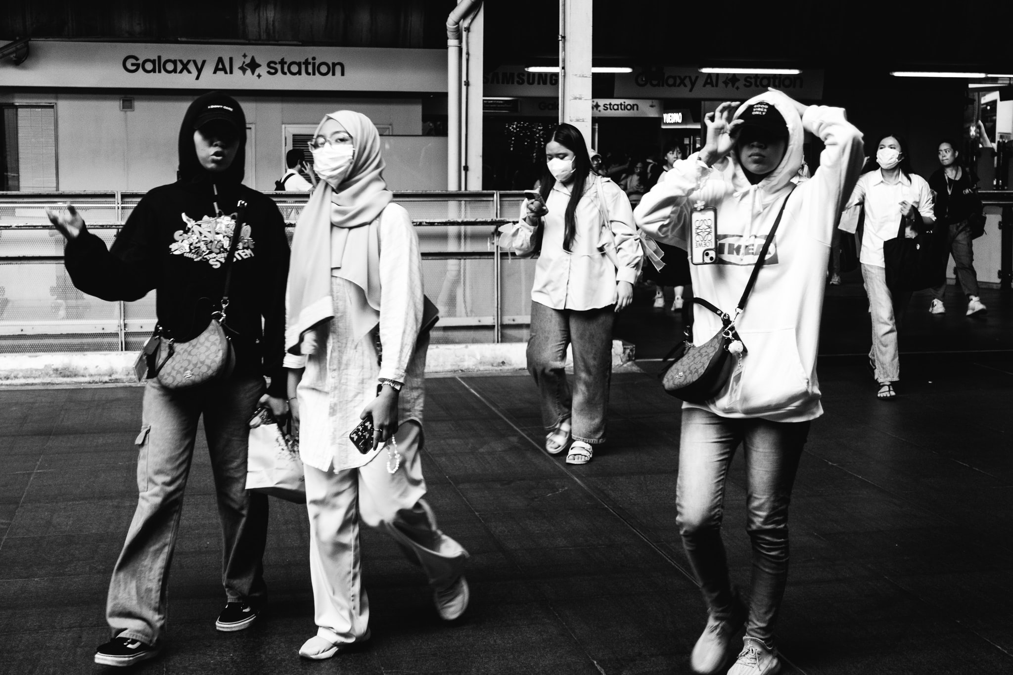 Black and white photo of a group of young people wearing face masks walking in Bangkok.