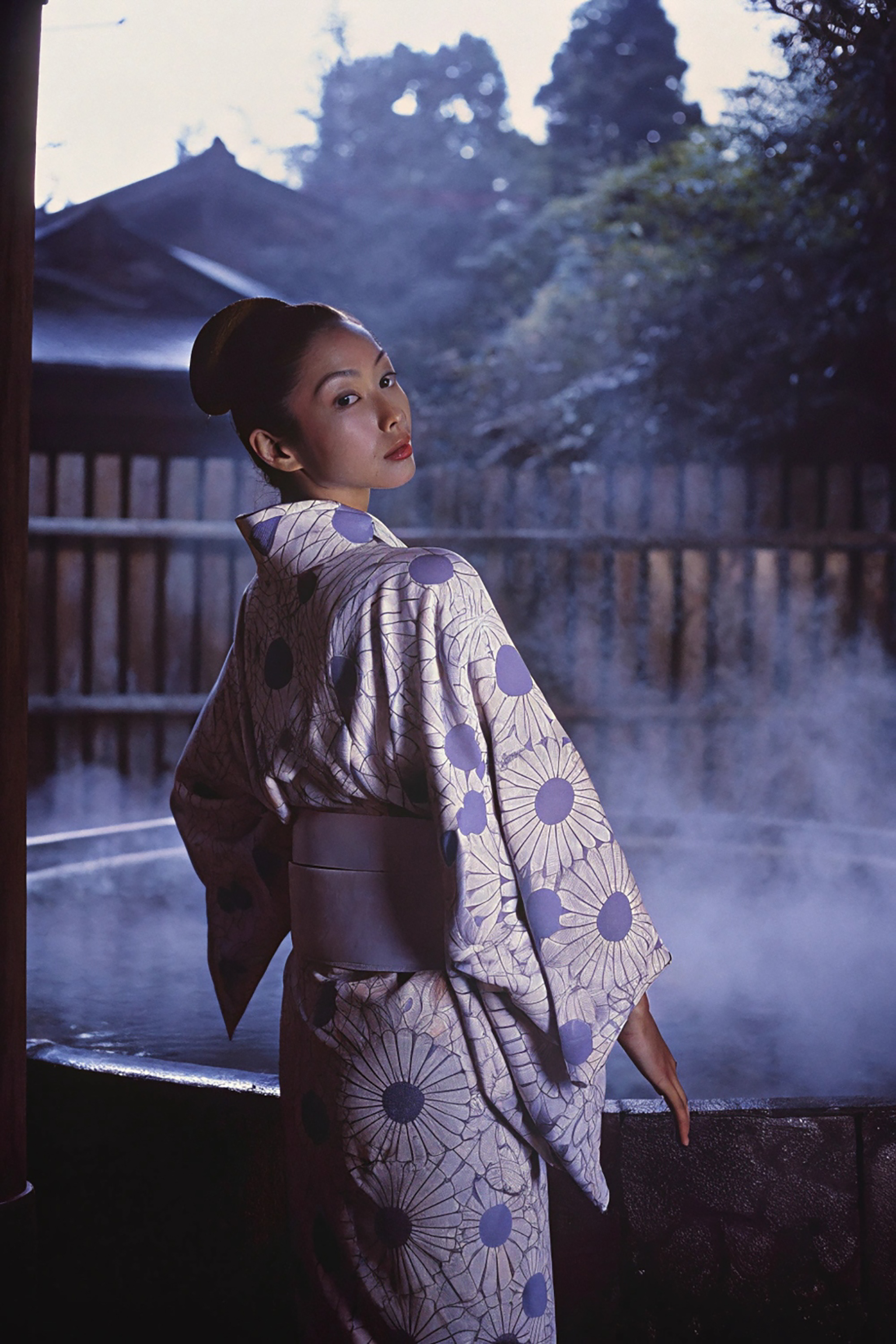 Woman in yukata at an onsen during blue hour.