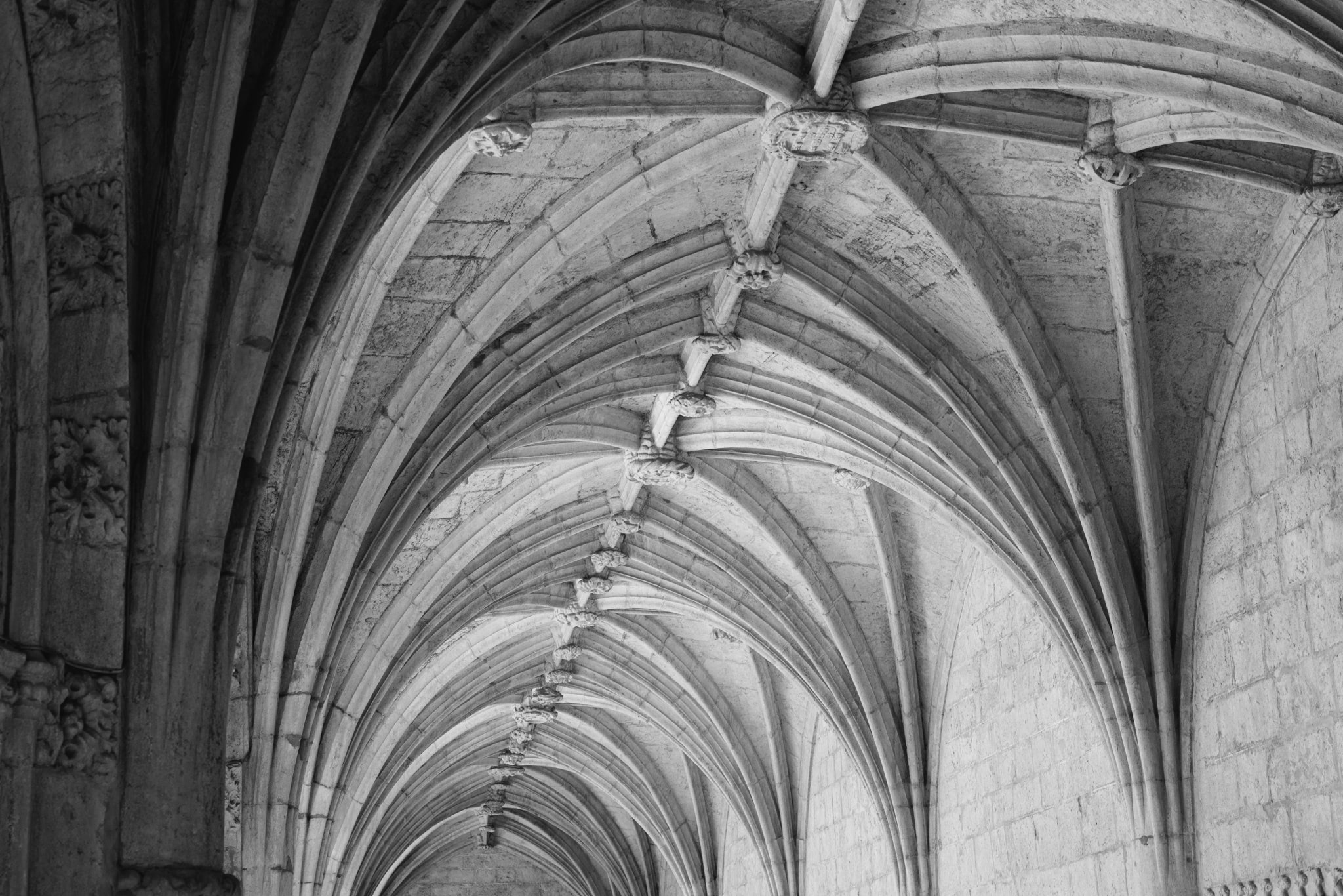 Black and white photo of the ornate ribbed vault ceiling of the Jerónimos Monastery.