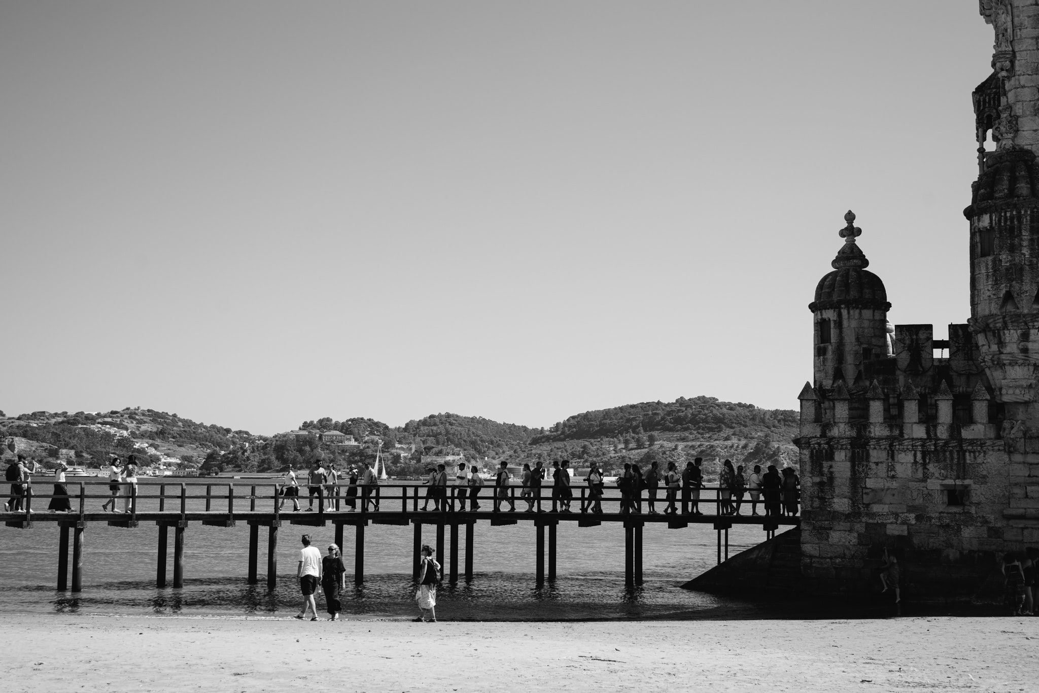 Belém Tower, Lisbon, with people on a pier.