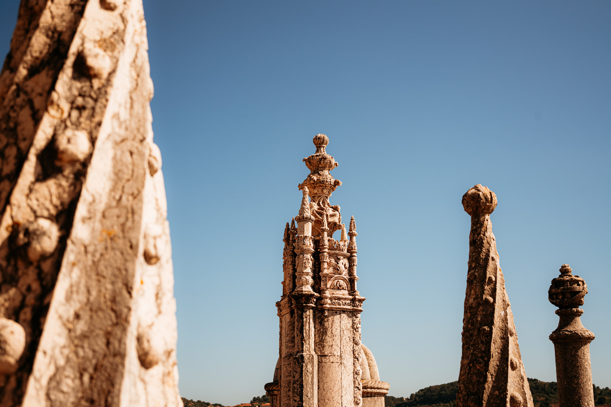 Close-up view of ornate stone spires against a clear blue sky.