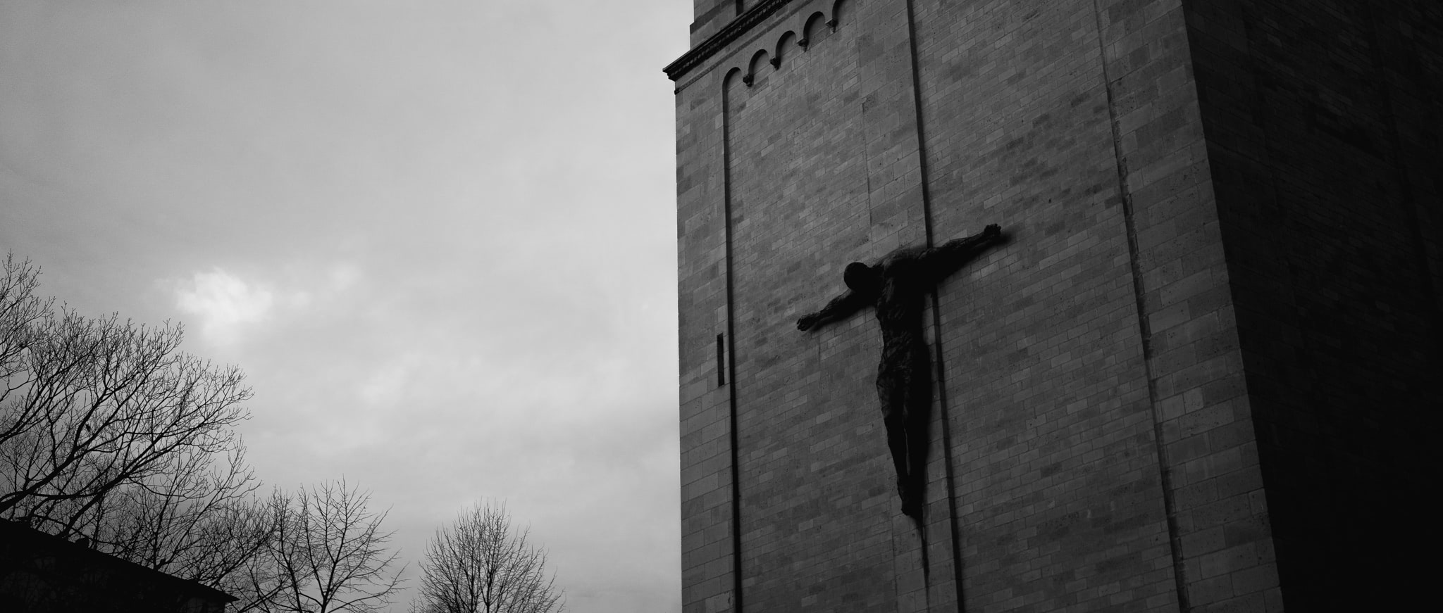 Black and white photo of a crucifix on a church exterior.