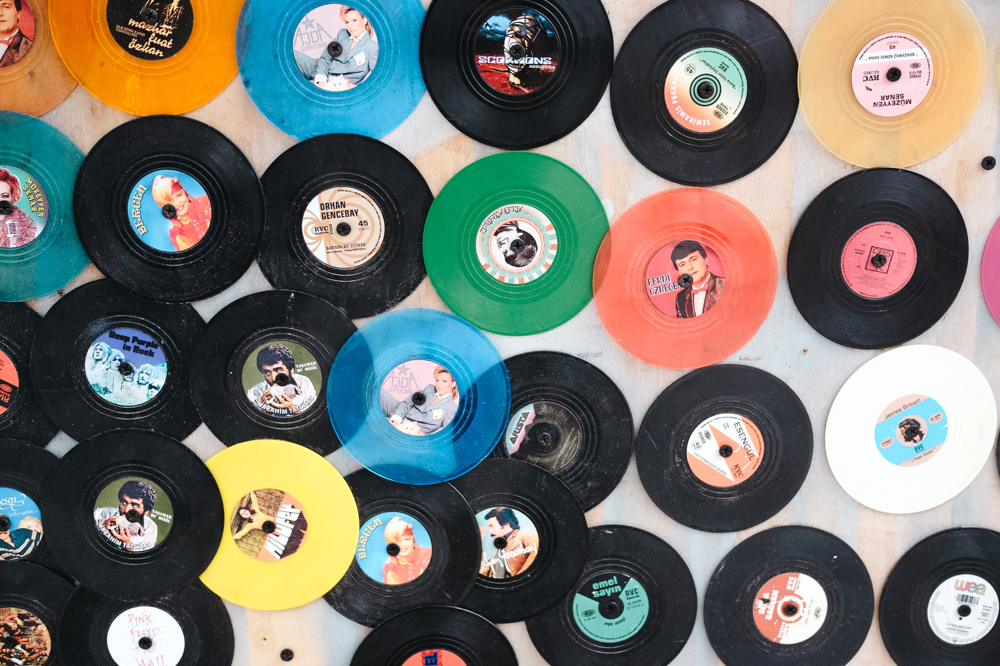 Collection of vintage colored vinyl records, including black, yellow, blue, green, orange, and white.