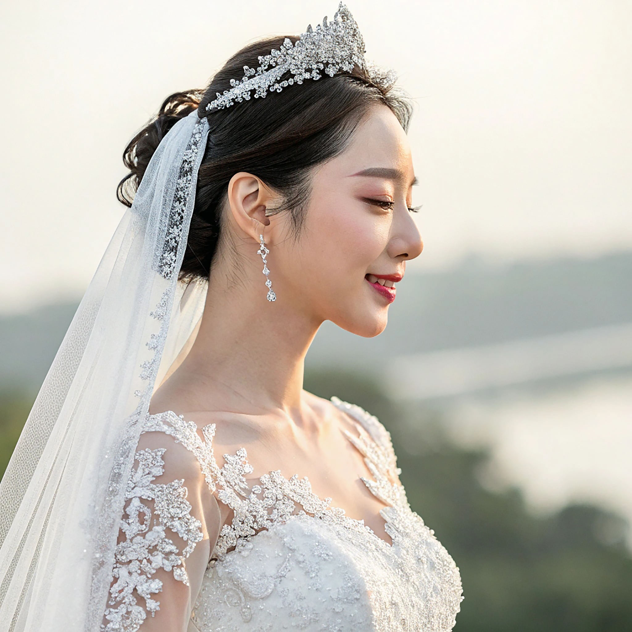 Asian woman in a wedding dress, crown, and veil looking off to the side.