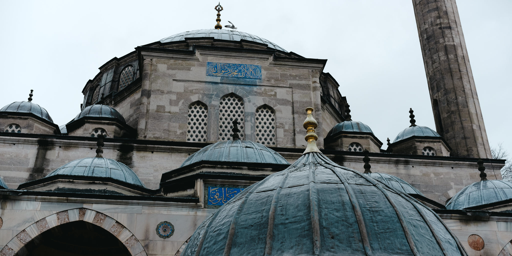 Close-up of an Ottoman mosque featuring domes, a minaret, and intricate details.