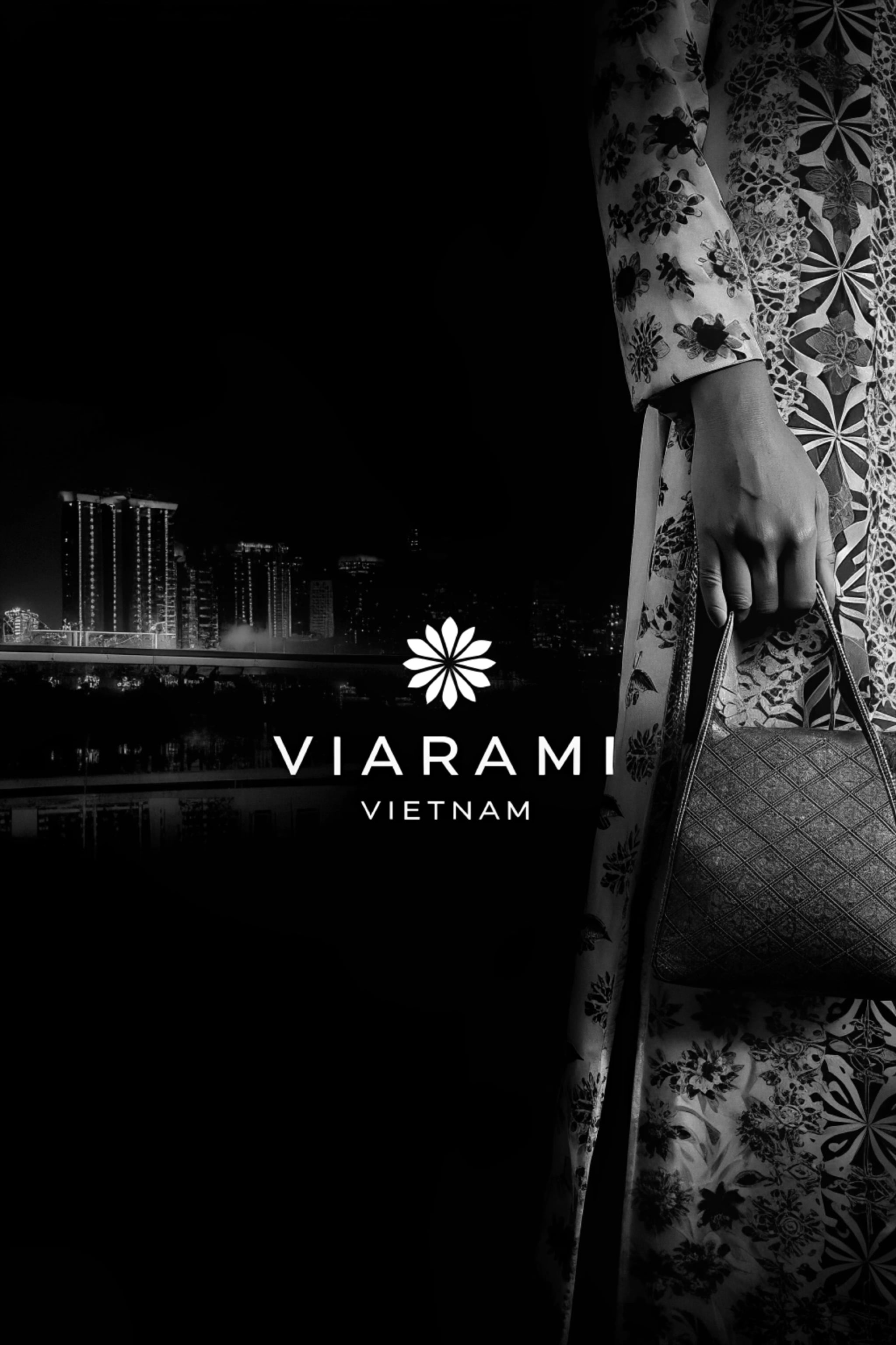 Black and white image of a woman in a floral dress holding a handbag with a cityscape in the background.