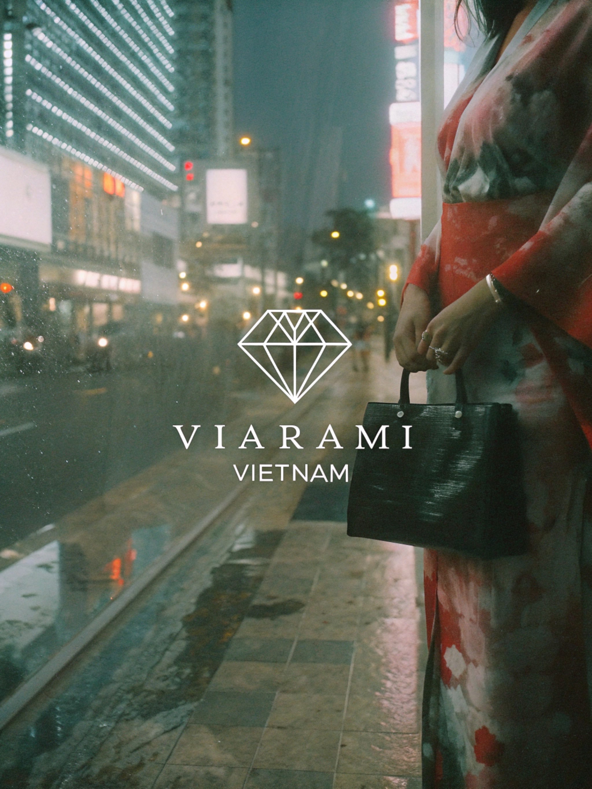 Woman in kimono holding a handbag in a rainy city.