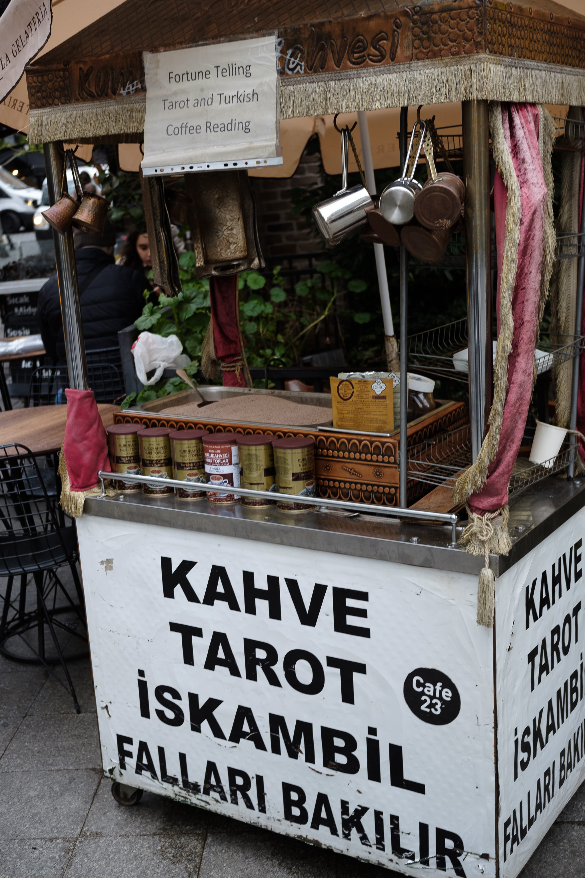 A fortune telling stall with a sign that reads 'Fortune Telling Tarot and Turkish Coffee Reading'.