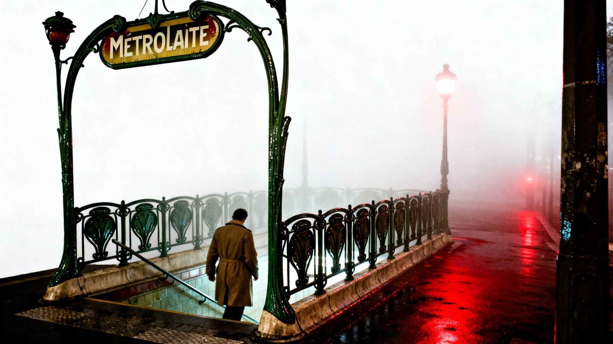 Moody fine-art photo of a dark green Art Nouveau Metropolitain station entrance in fog, with a figure descending.