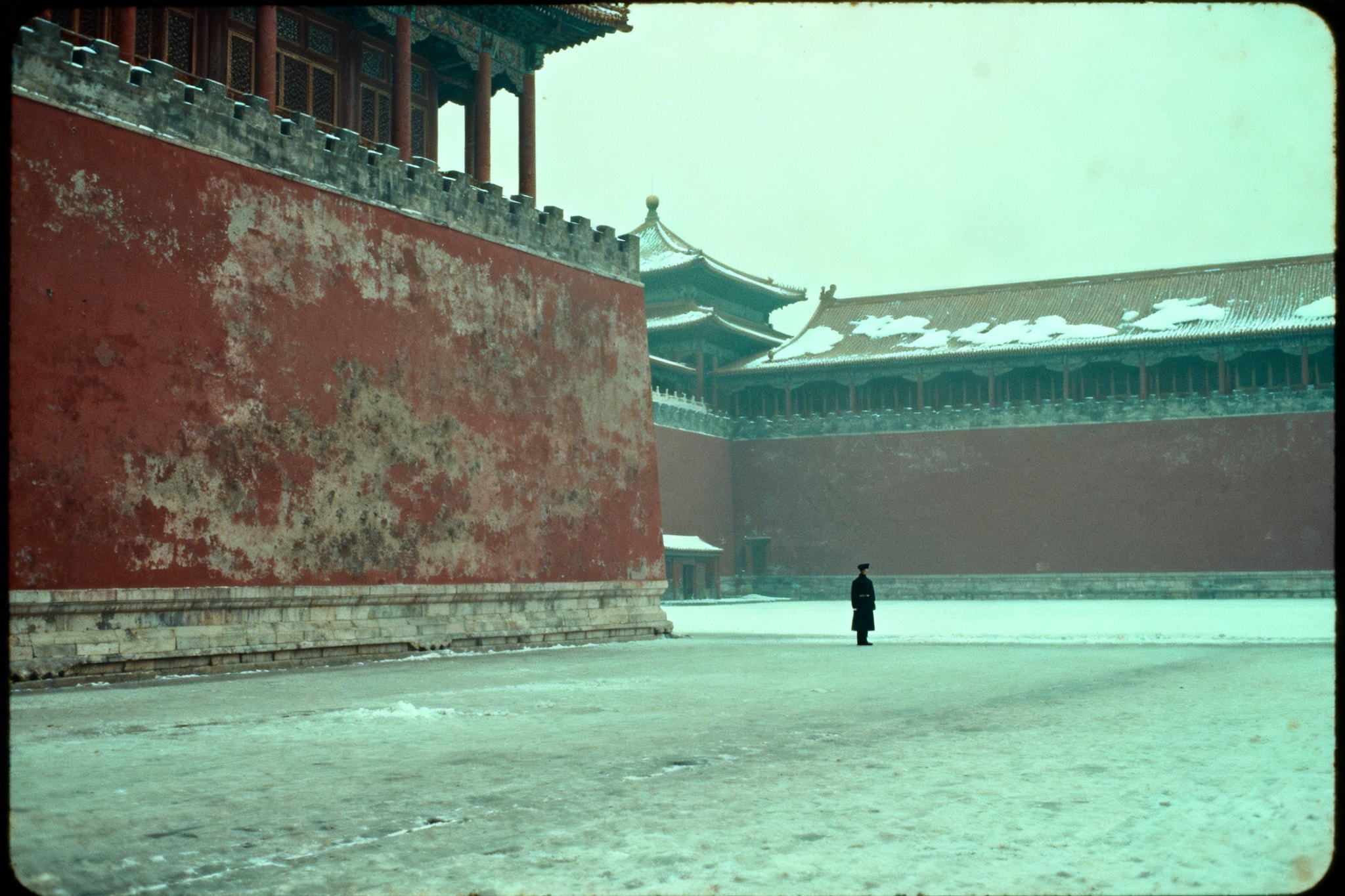 A lone guard standing in a snowy courtyard of the Forbidden City in Beijing.