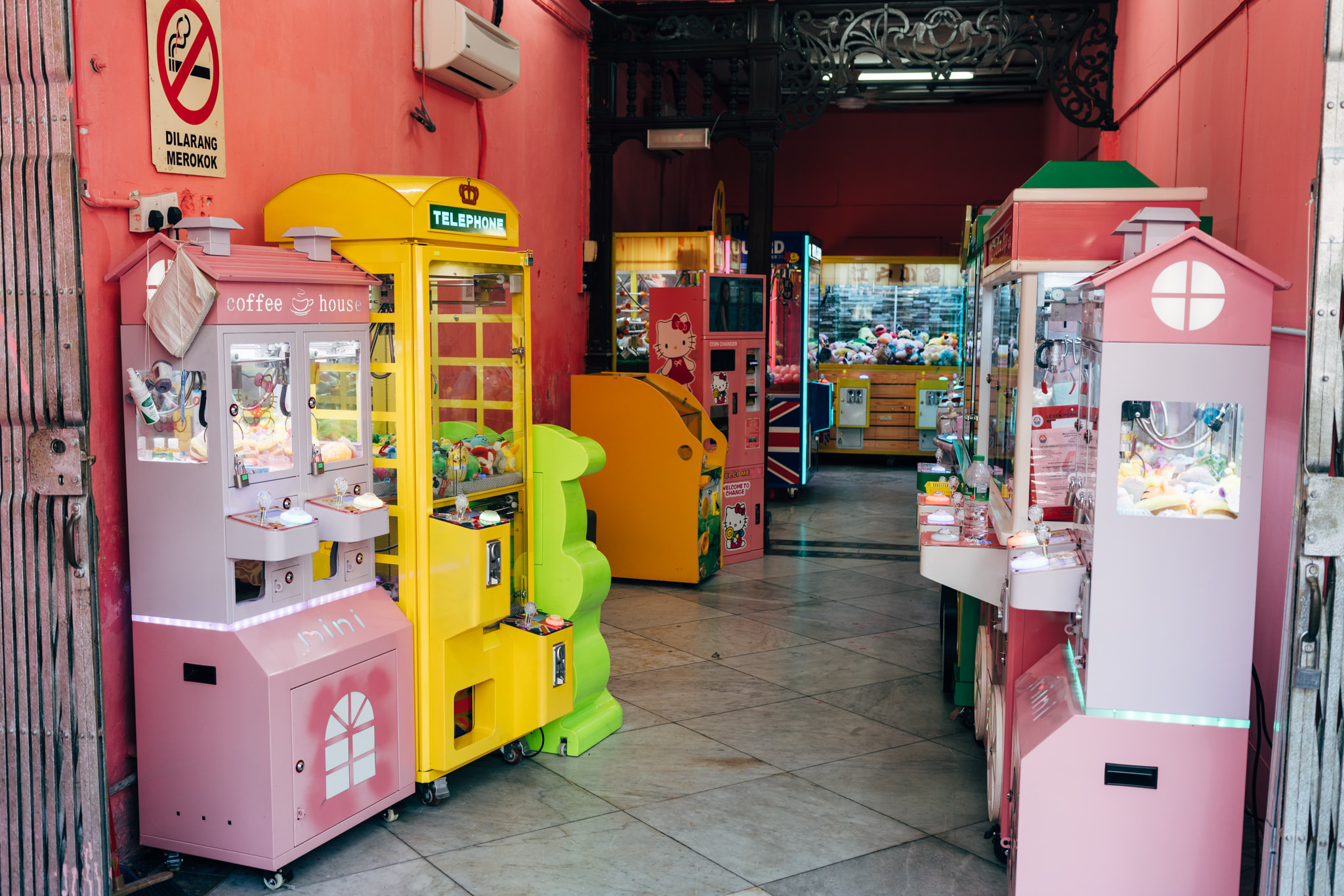 Colorful claw machines and vending units in a vibrant arcade hallway